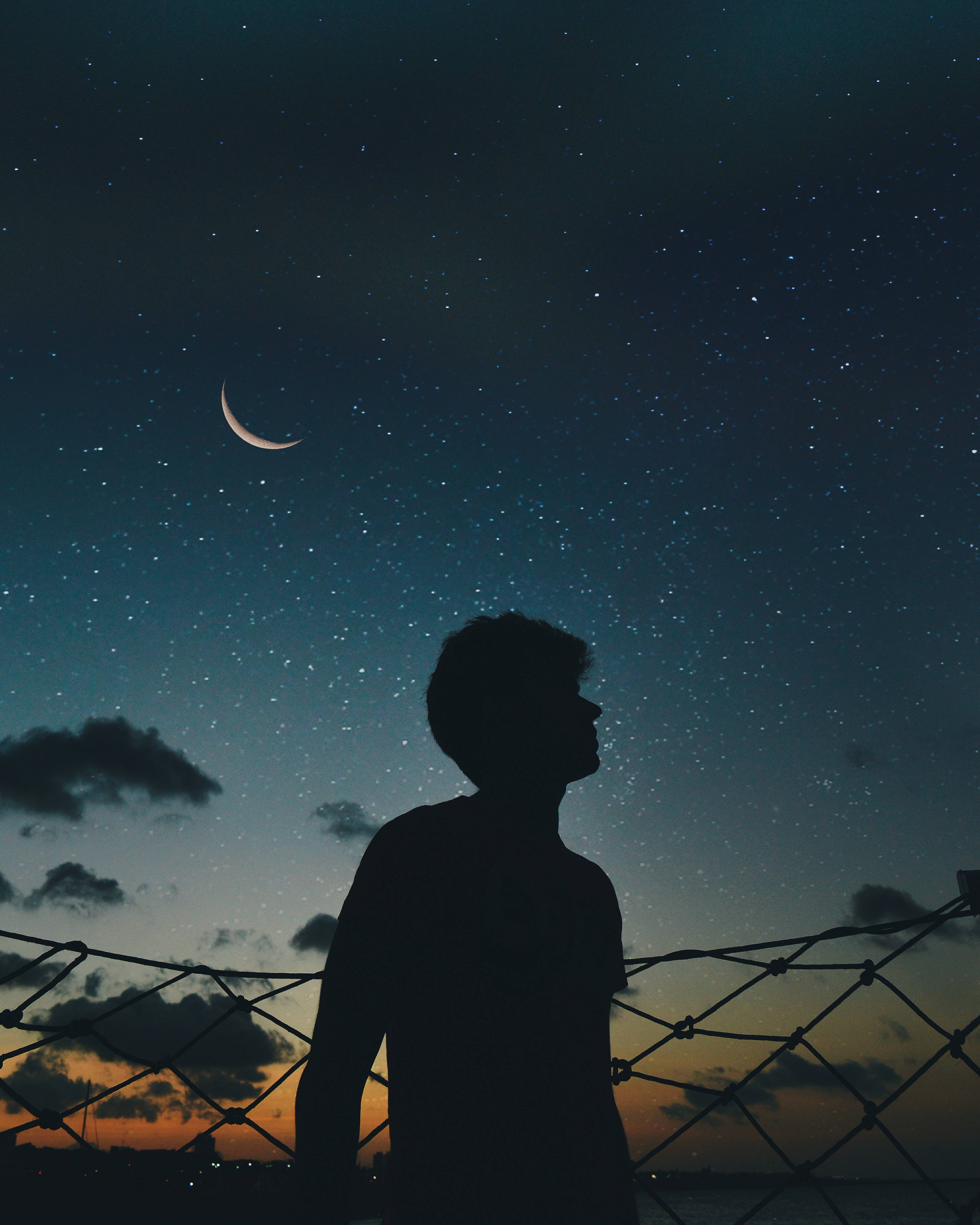 Silhouette 桌布 壁紙 — 一個人的剪影仰望被鐵絲網圍繞的彎月和星空。