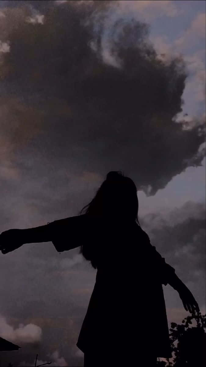 shadow 桌布 壁紙 — 一個人的剪影在充滿旋轉烏雲的戲劇性暮色天空下張開雙臂站立。