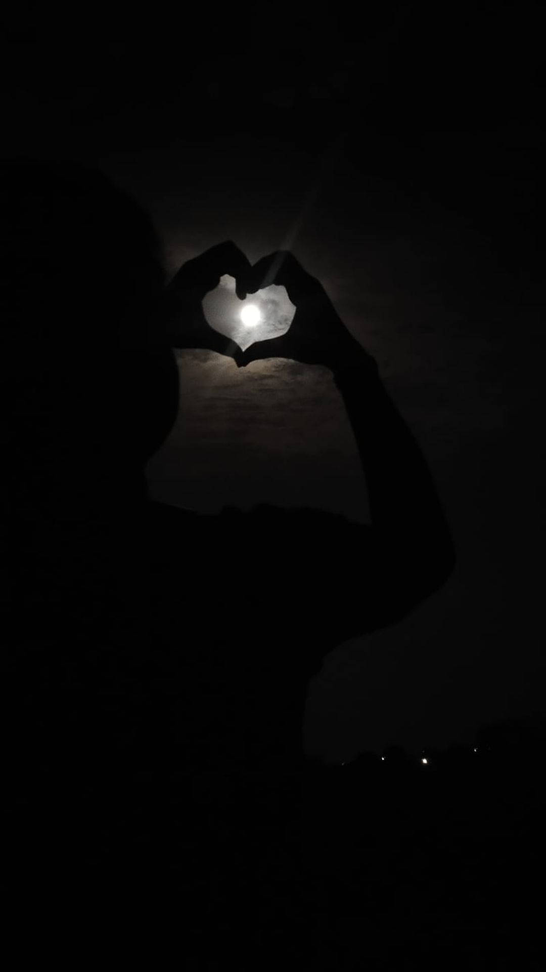 黑色愛心 桌布 壁紙 — 一個人的剪影在黑暗的夜空下，雙手比出心形環繞著發光的月亮。