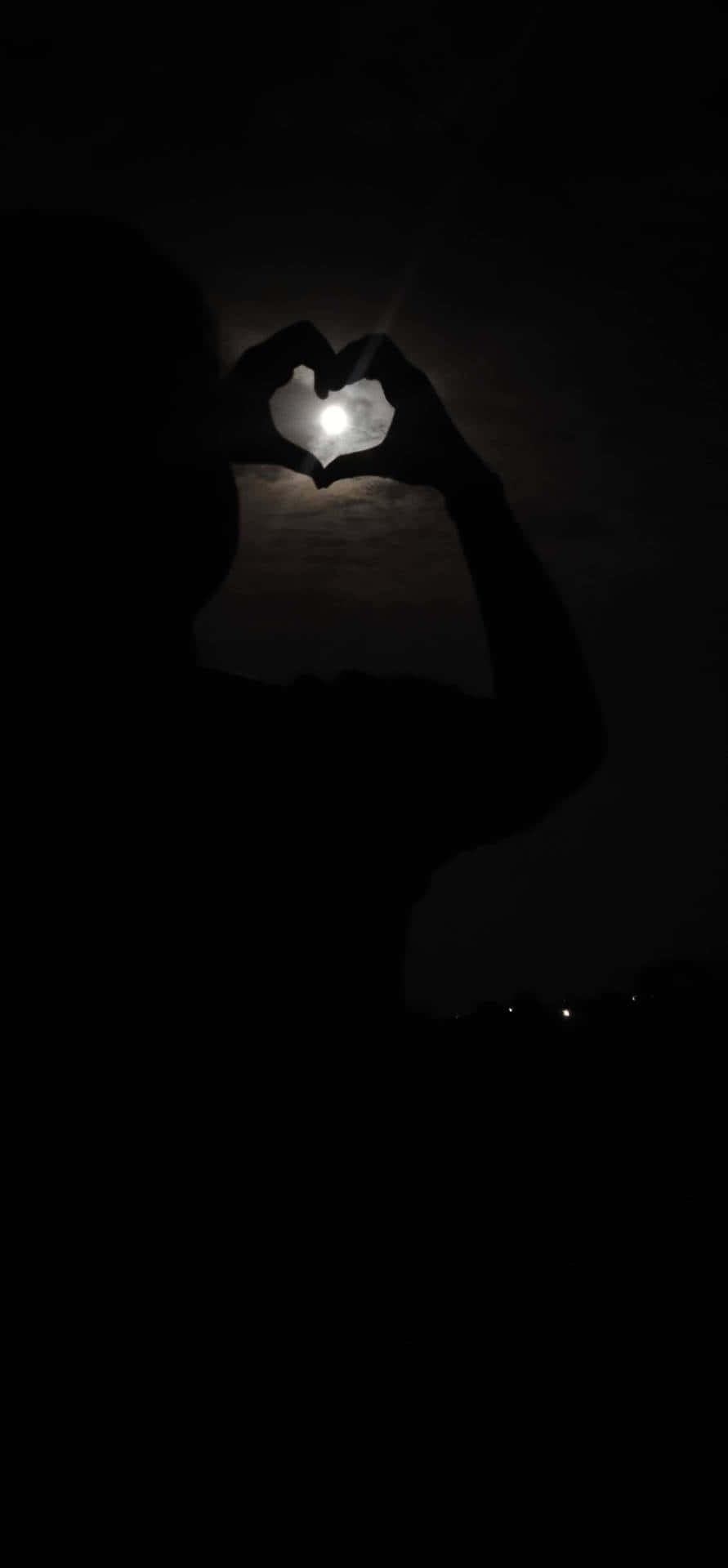 愛心 桌布 壁紙 — 一個人的剪影將發光的月亮框成心形，映襯著黑暗的夜空。