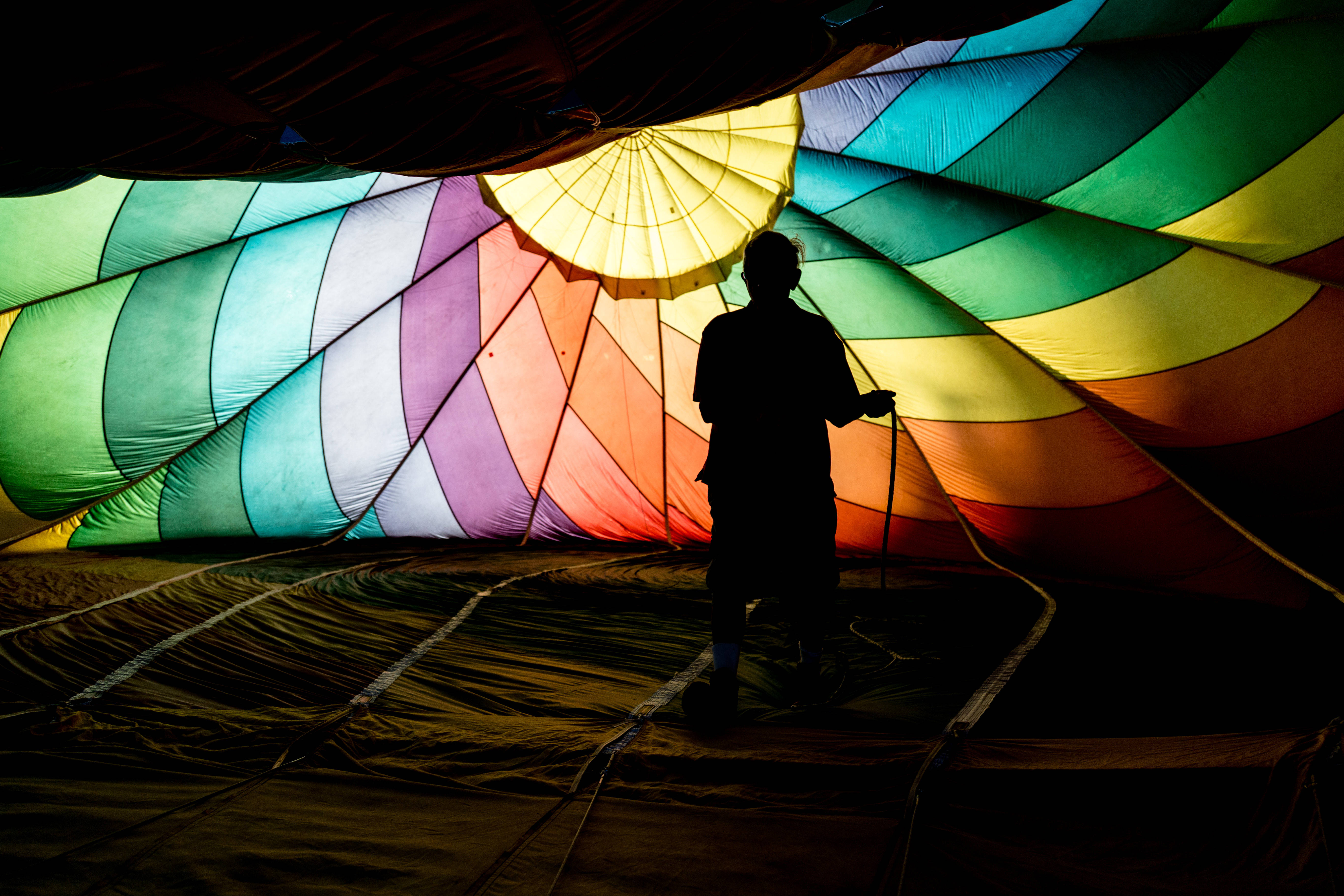 Stripes 桌布 壁紙 — 一個人的剪影站在一個色彩繽紛的熱氣球內部，從內部發出彩虹色光芒。
