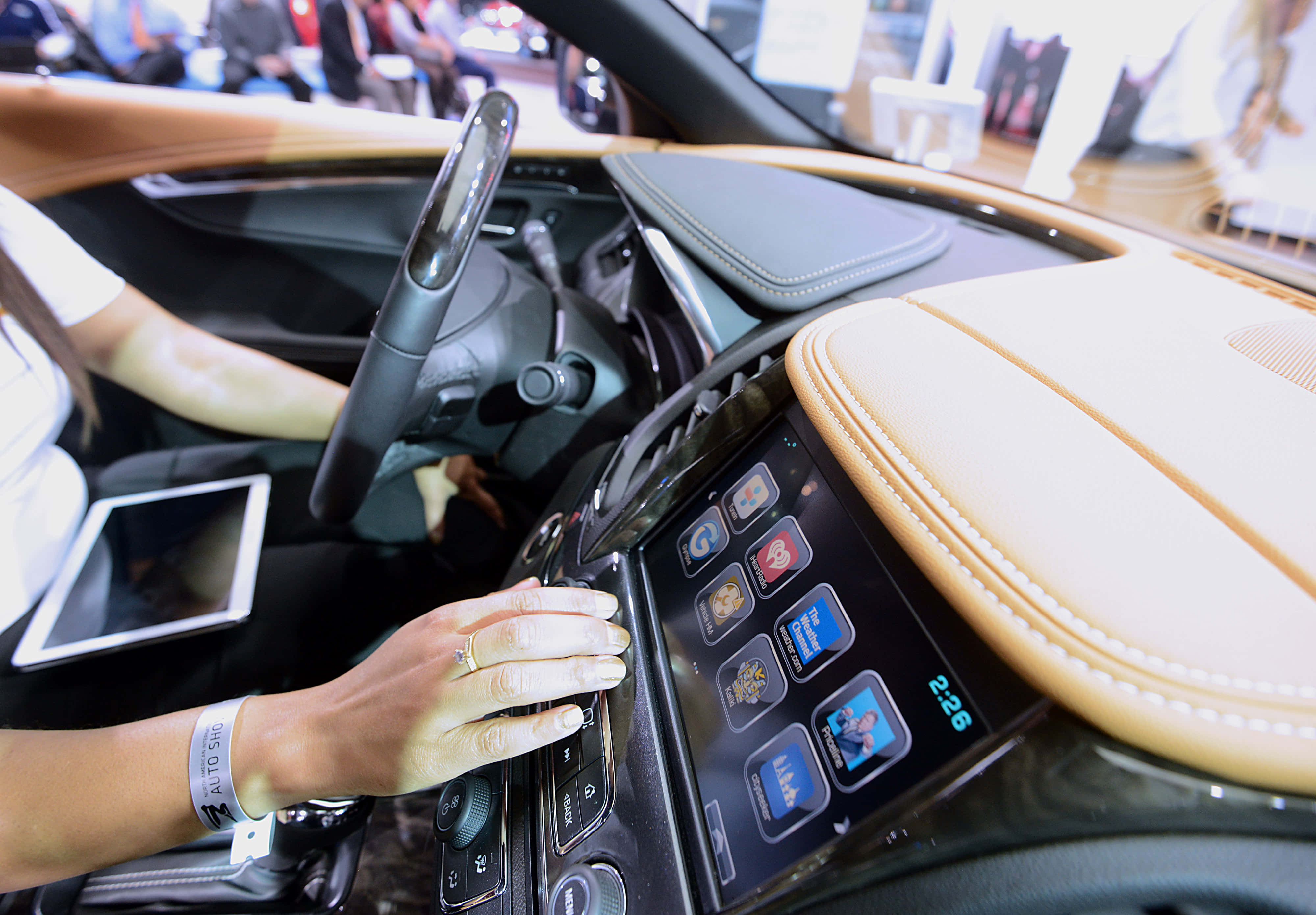 Car Technology 桌布 壁紙 — 一個人的手在展廳環境中與未來主義汽車的觸控螢幕控制台和排檔選擇器互動。