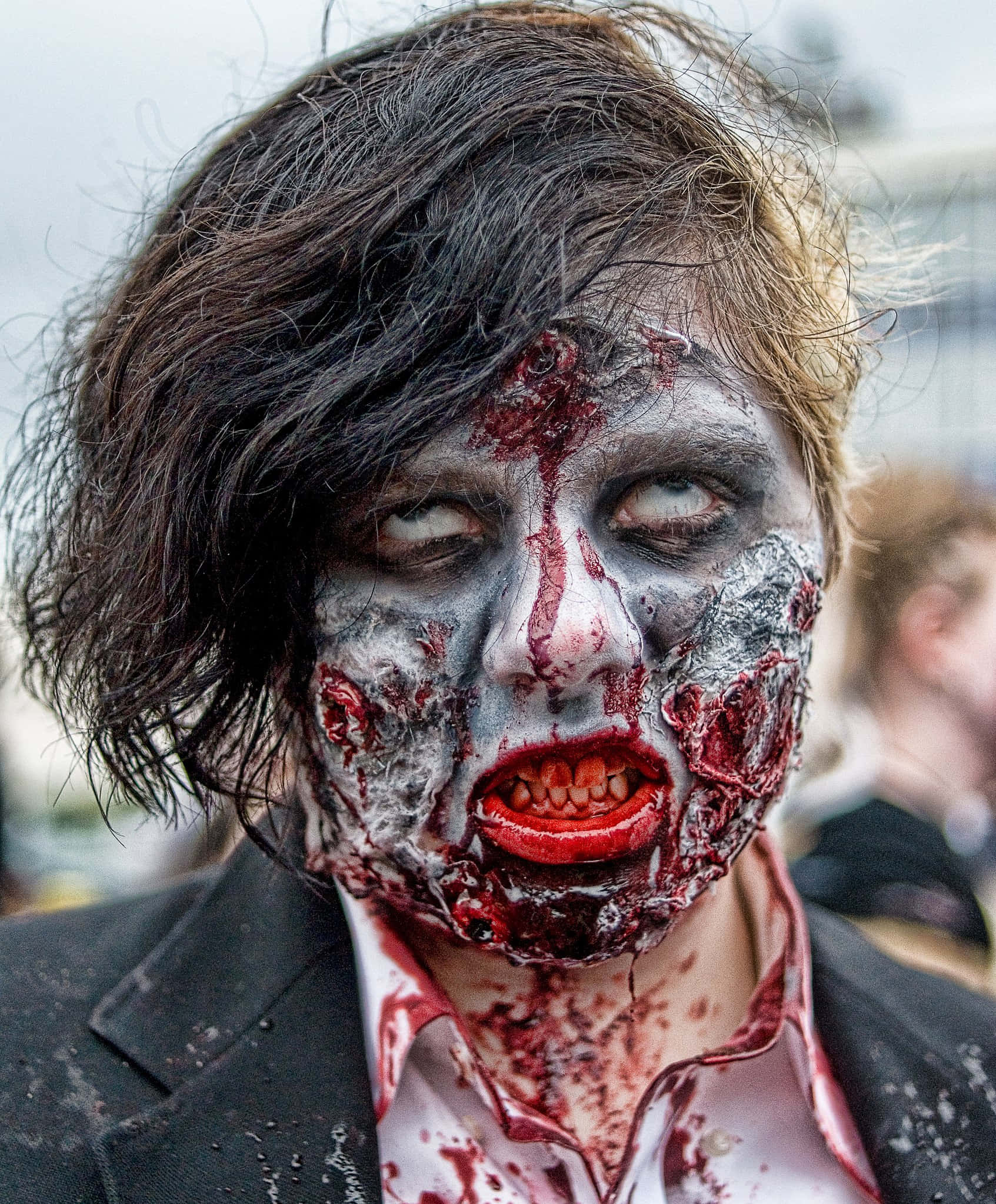 Scary Zombie 桌布 壁紙 — 一個人的特寫，臉上畫著可怕的殭屍妝，有血淋淋的牙齒和撕裂皮膚的效果。