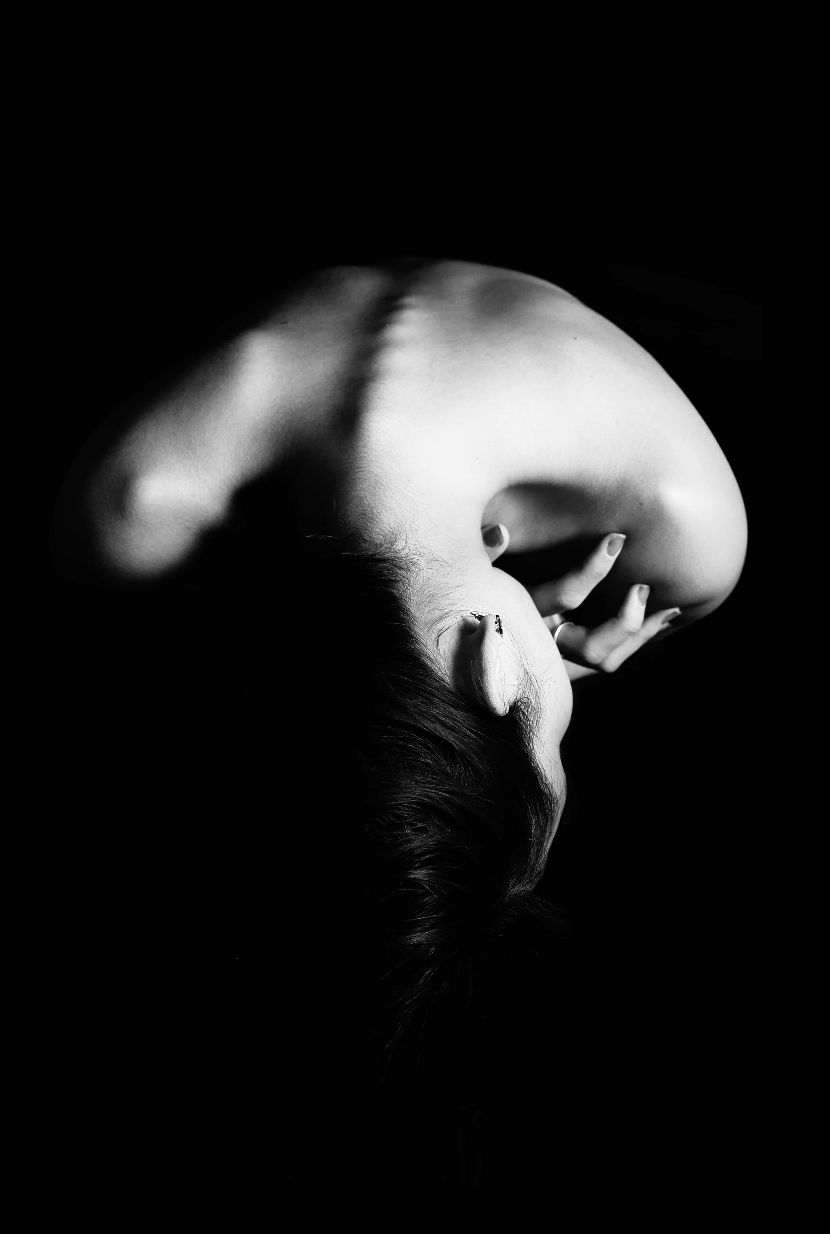 Woman 桌布 壁紙 — 一個人的背部和頭部向下傾斜的黑白肖像，背景黑暗，光線戲劇性。