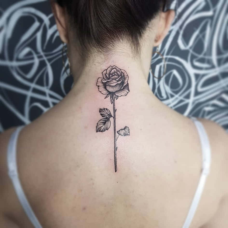 Tattoo Girl 桌布 壁紙 — 一個人的背部展示了一個精細的黑玫瑰刺青，沿著脊椎向下延伸，背景是旋轉的抽象圖案。