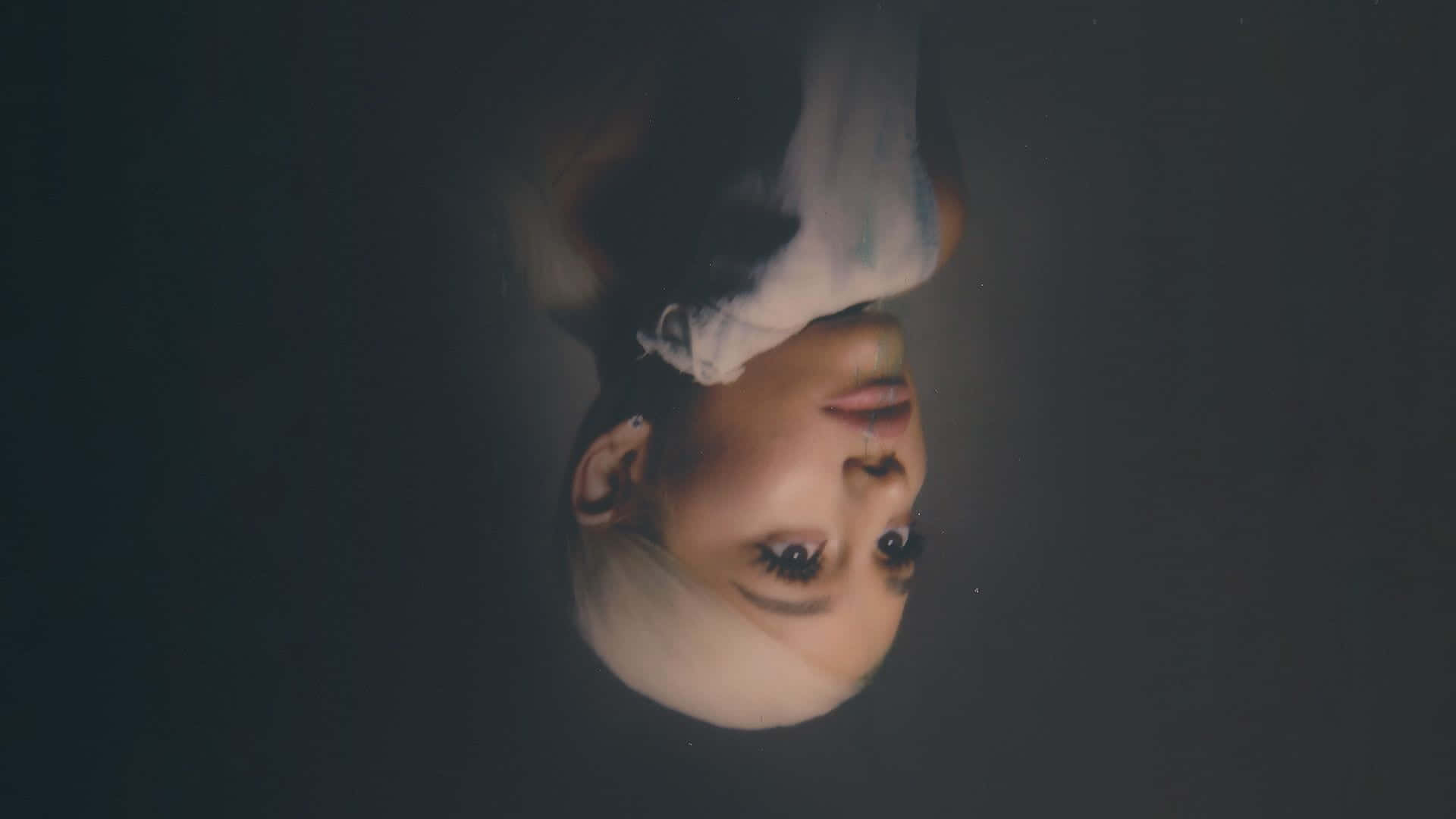 Aesthetic Ariana Grande 桌布 壁紙 — 一個人的臉倒轉浸在暗水中，光線從他們的眼睛和頭髮反射出來。