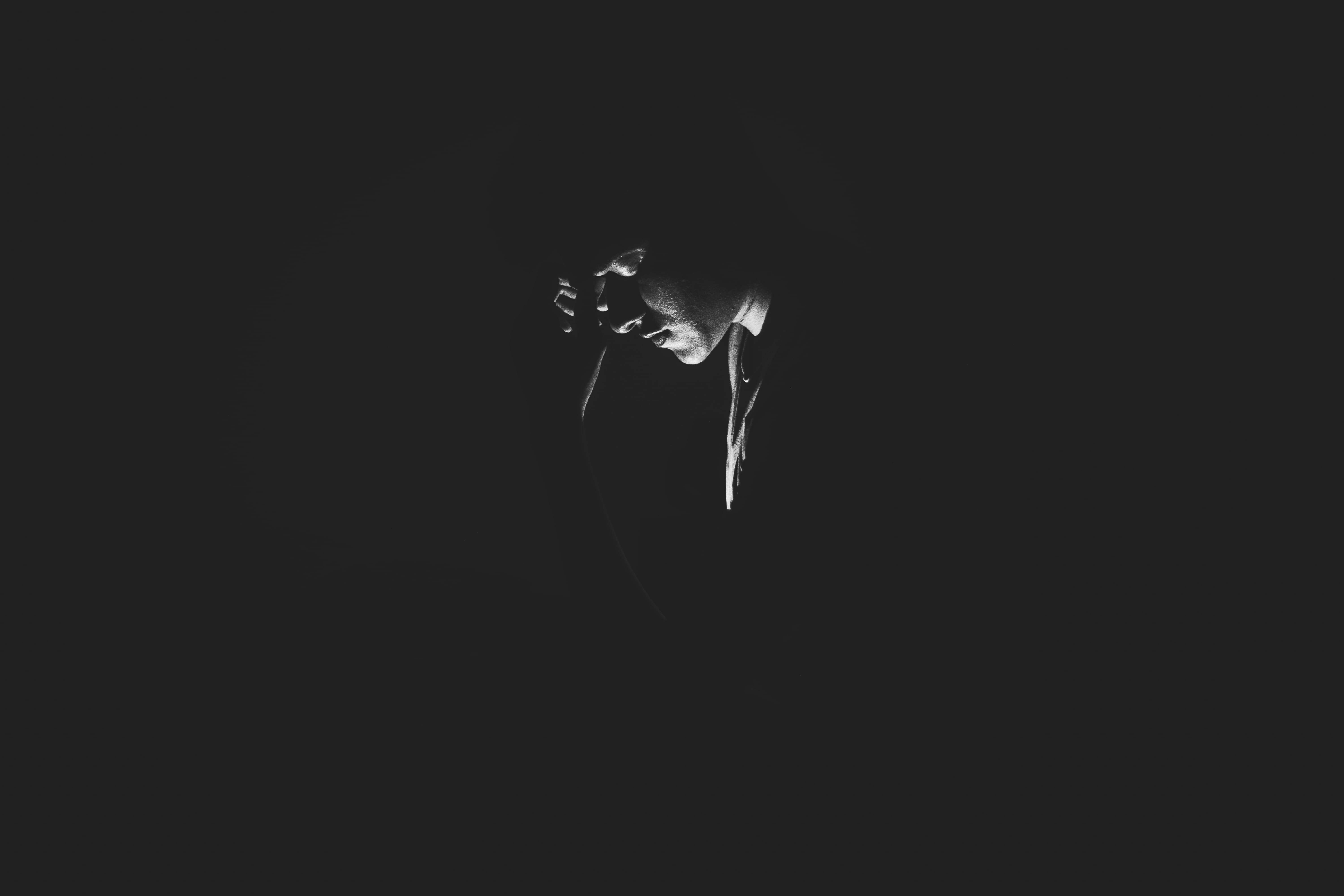 Alone Boy 桌布 壁紙 — 一個人的臉在漆黑背景中隱約被照亮，形成鮮明而富有氣氛的剪影。
