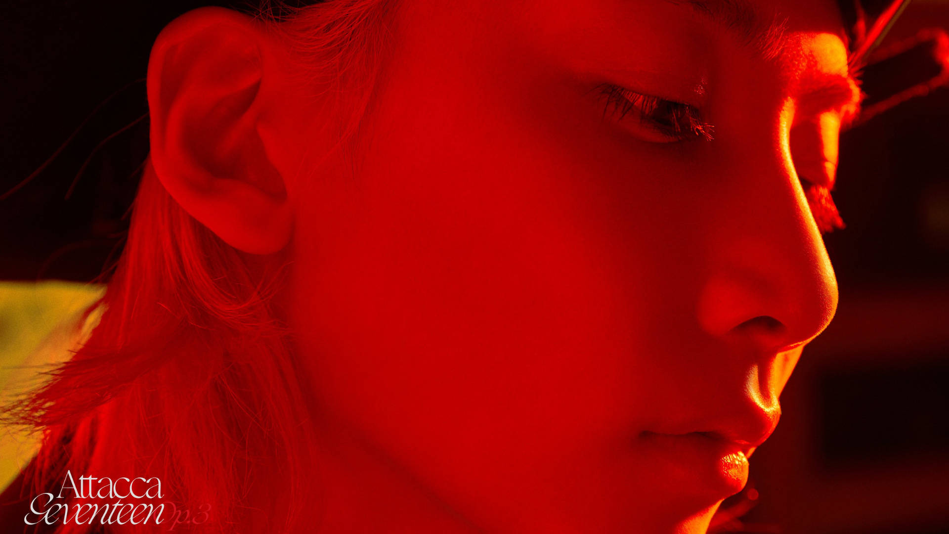 yoon jeonghan 桌布 壁紙 — 一個人的臉龐沐浴在強烈的紅光中，柔和的陰影突顯了他們的側面和閉上的眼睛。