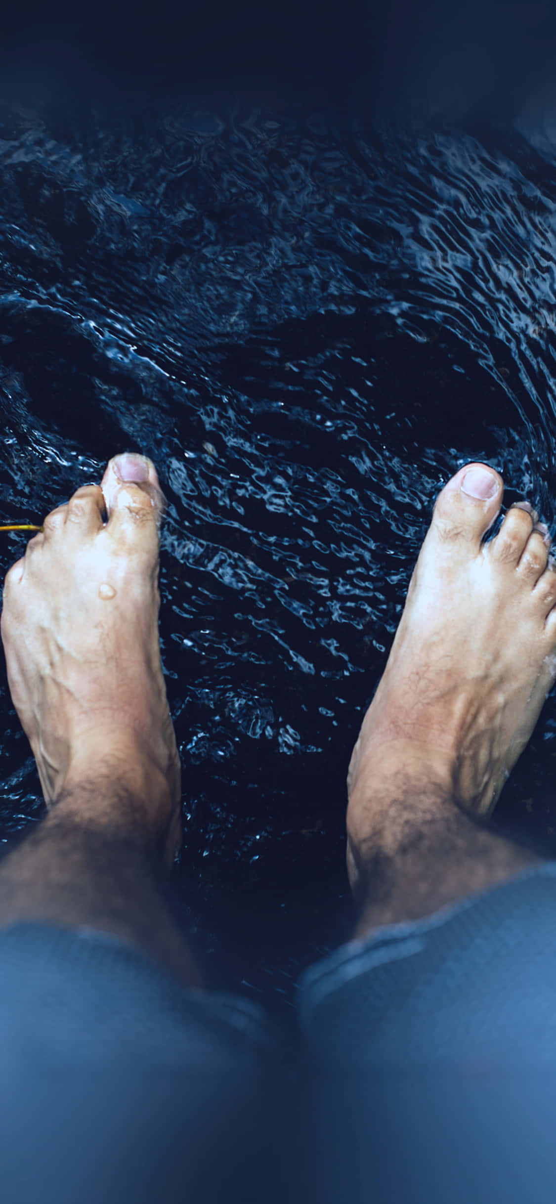 feet 桌布 壁紙 — 一個人的赤腳站在深暗的水中，周圍有漣漪旋轉。