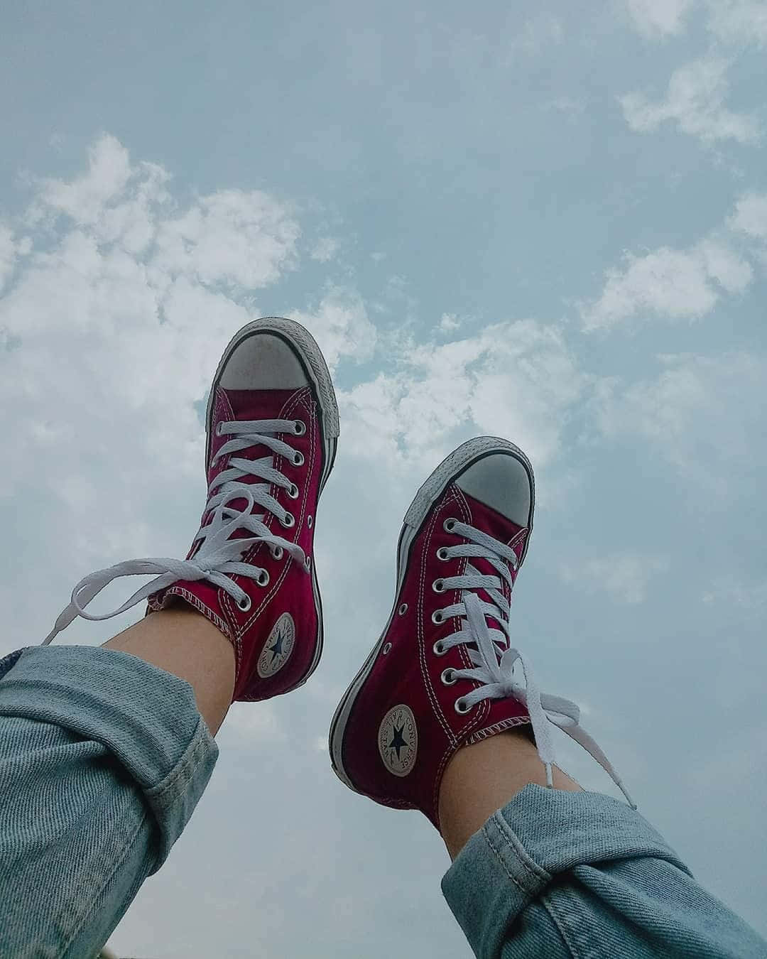 一個人的雙腳穿著紅色Converse帆布鞋 壁紙