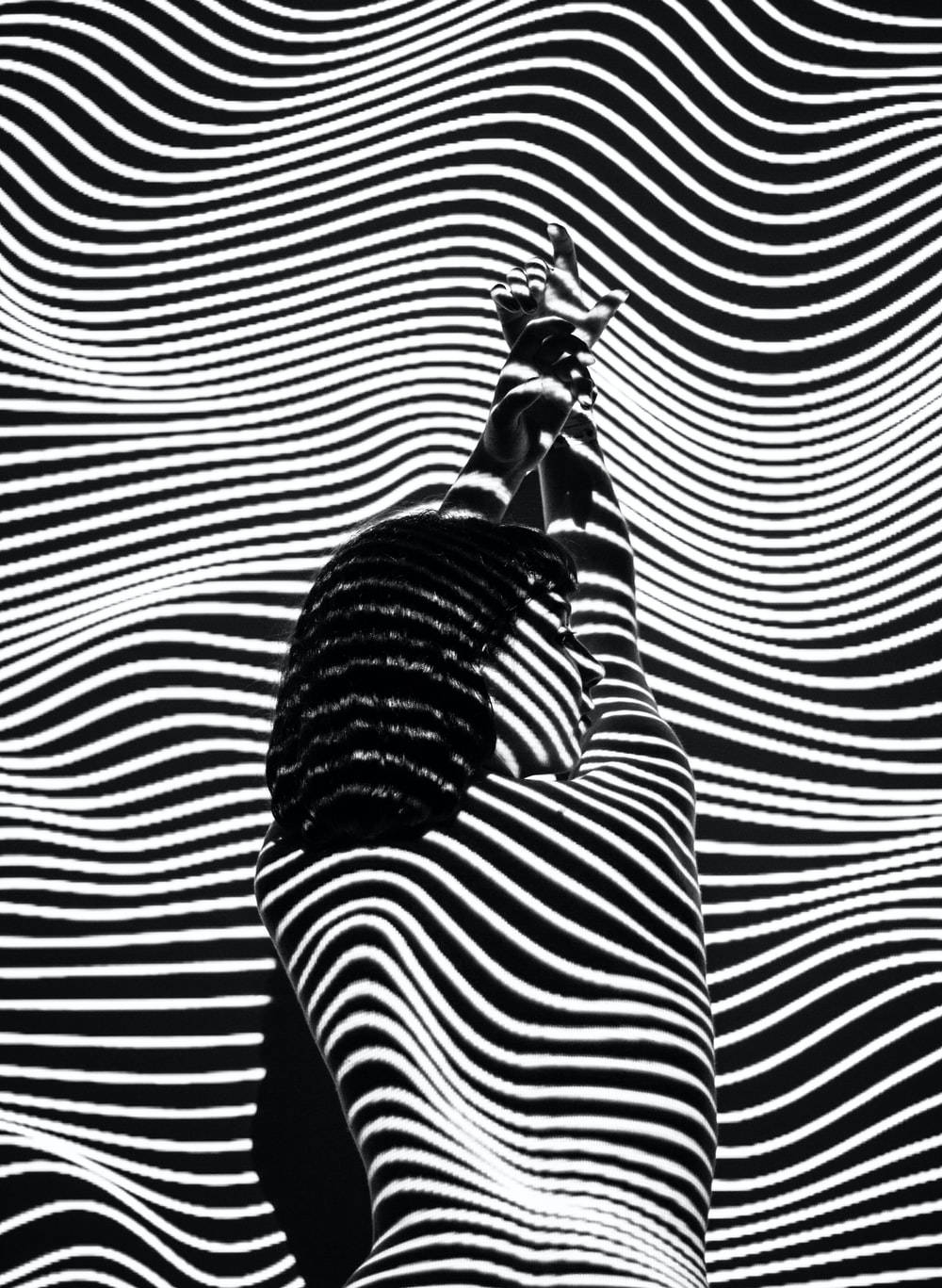 shadow 桌布 壁紙 — 一個人的黑白剪影，雙臂高舉，背景是催眠般的波浪條紋。