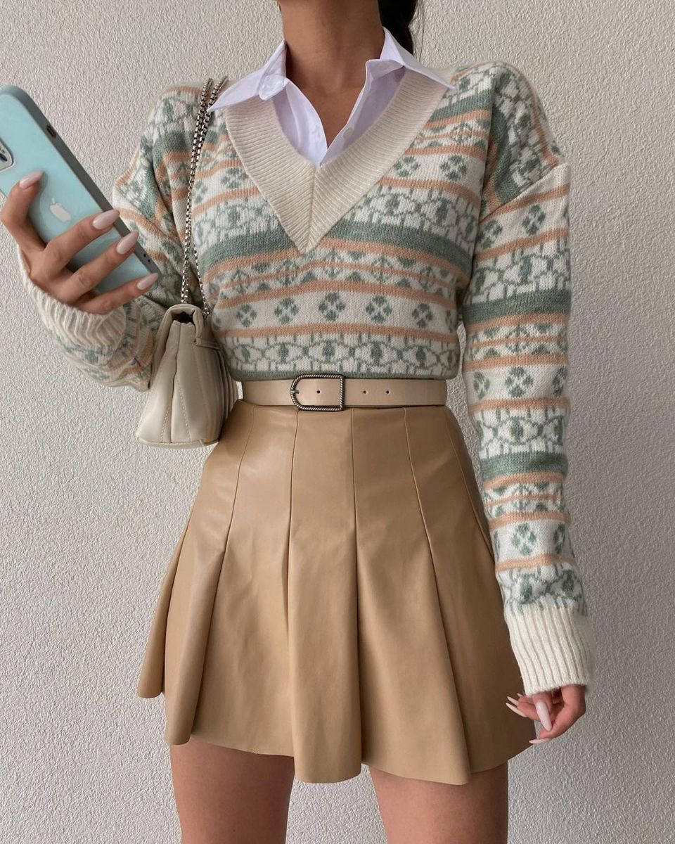Clothes 桌布 壁紙 — 一個人穿著圖案針織毛衣內搭白襯衫，搭配米色百褶裙，同時手持電話。