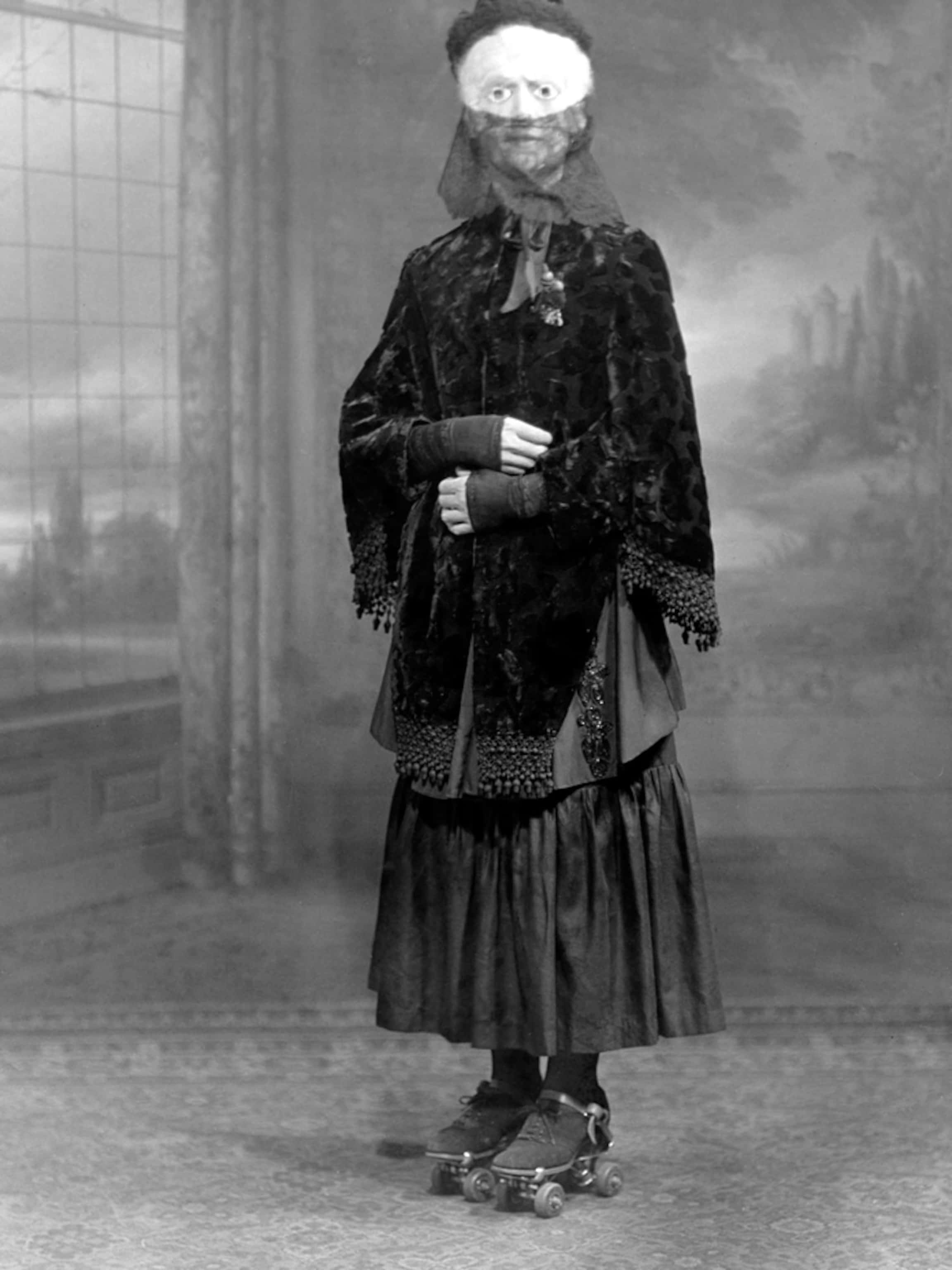 Creepy Halloween 桌布 壁紙 — 一個人穿著復古深色天鵝絨服裝和溜冰鞋，站在一個有彩繪背景的工作室裡。