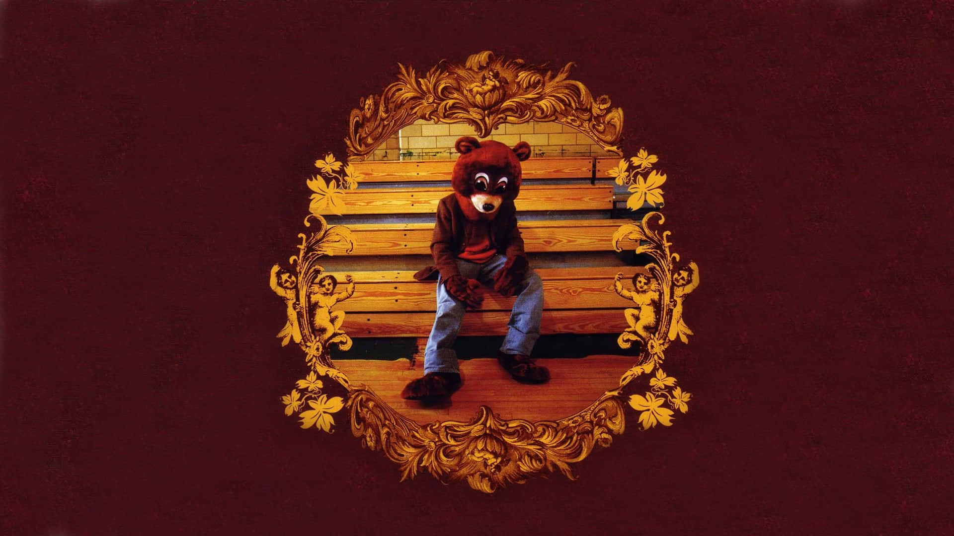 Kanye West Yeezus 桌布 壁紙 — 一個人穿著棕色熊吉祥物服裝坐在木長椅上，周圍是華麗的金色邊框，背景為深紅色。