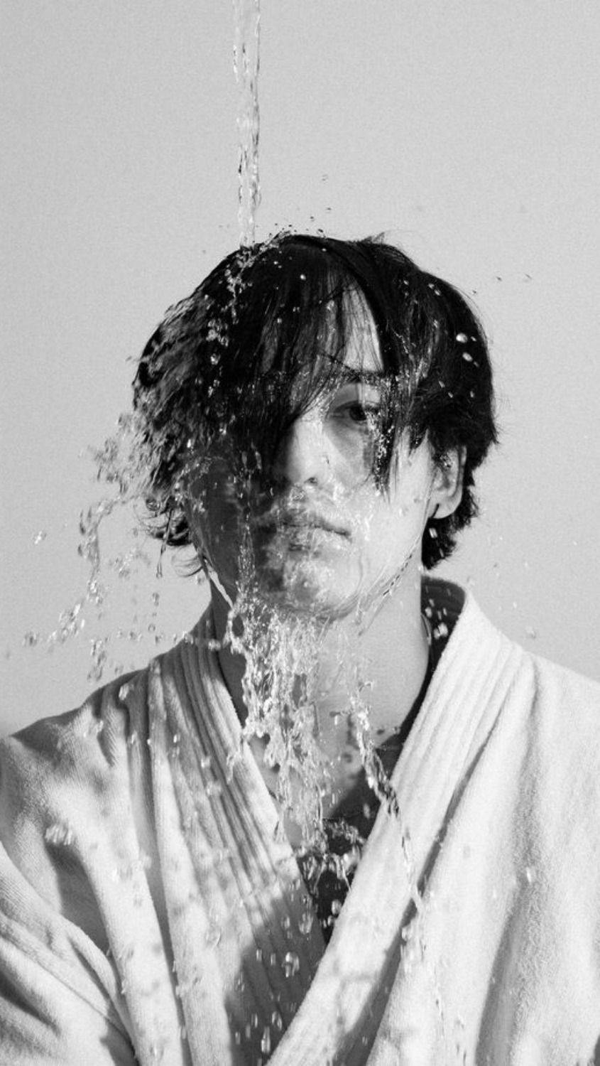 joji 桌布 壁紙 — 一個人穿著浴袍，水從臉上傾瀉而下，黑白對比強烈。