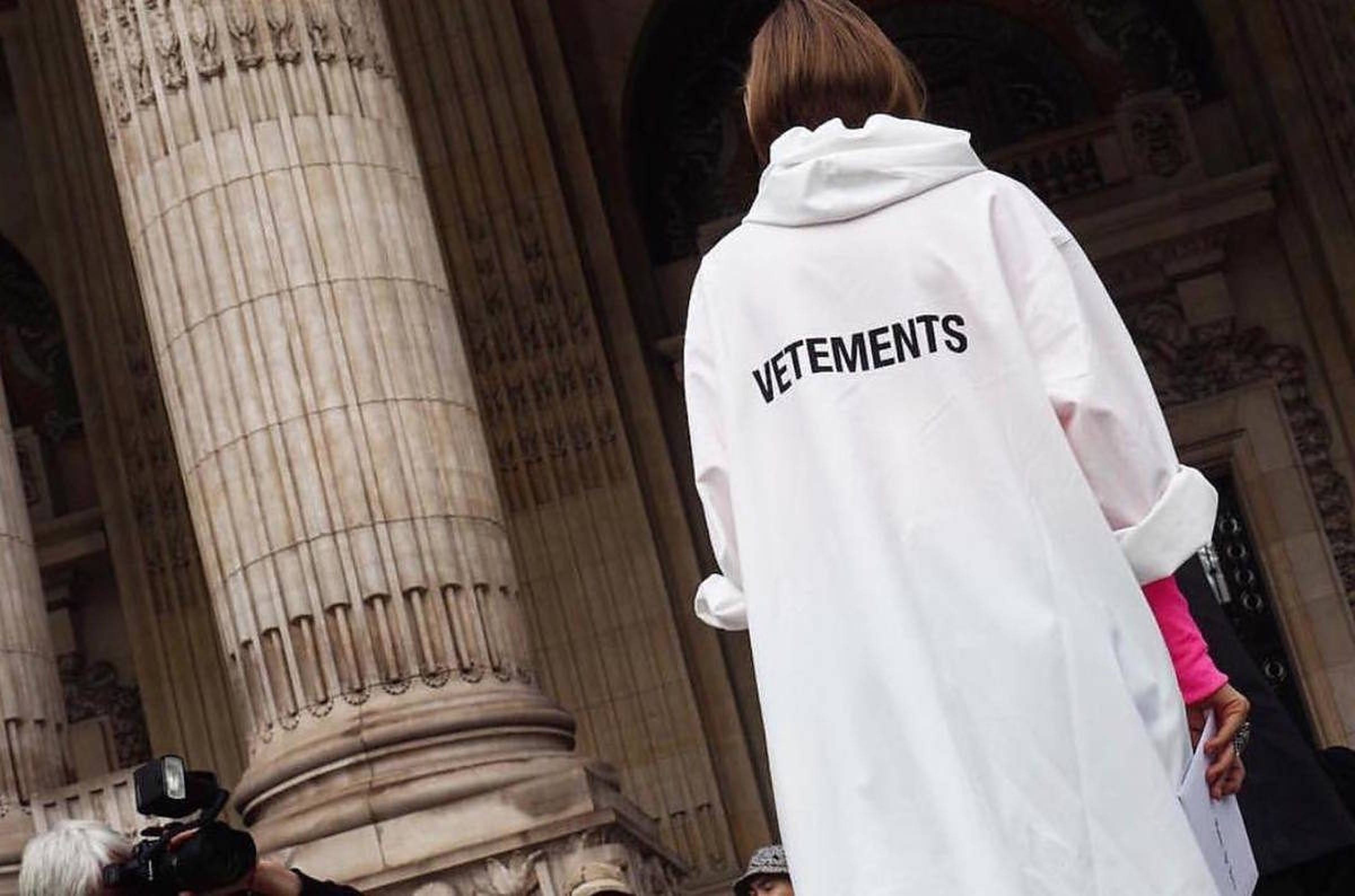 Vetements 桌布 壁紙 — 一個人穿著白色Vetements連帽衫，站在古典建築的巨大石柱前。