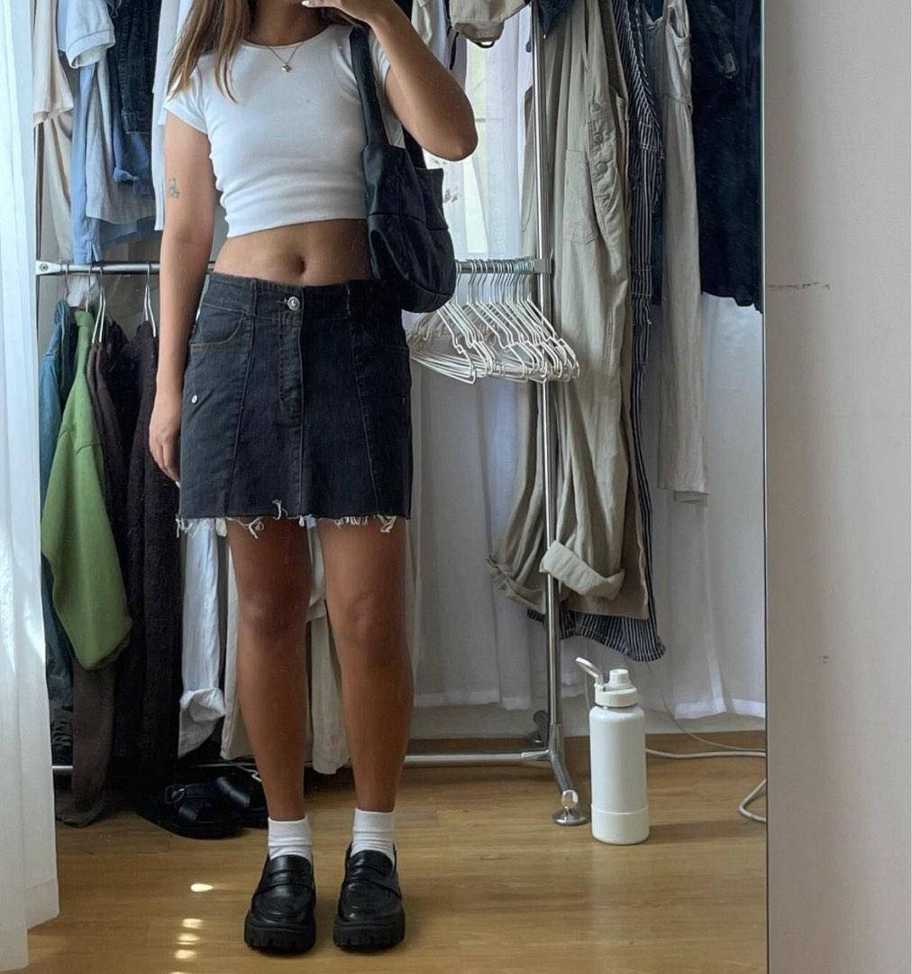 Trendy Aesthetic 桌布 壁紙 — 一個人穿著白色短上衣和深色牛仔裙，站在衣櫃鏡前拿著電話。
