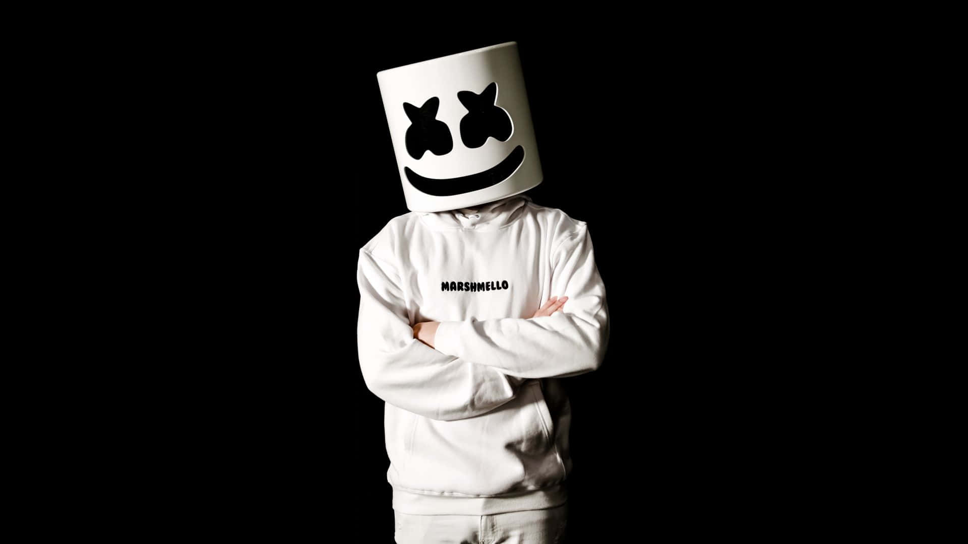 Marshmello 動態圖 桌布 壁紙 — 一個人穿著白色連帽衫和標誌性的棉花糖頭盔，雙臂交叉，站在純黑色背景前。