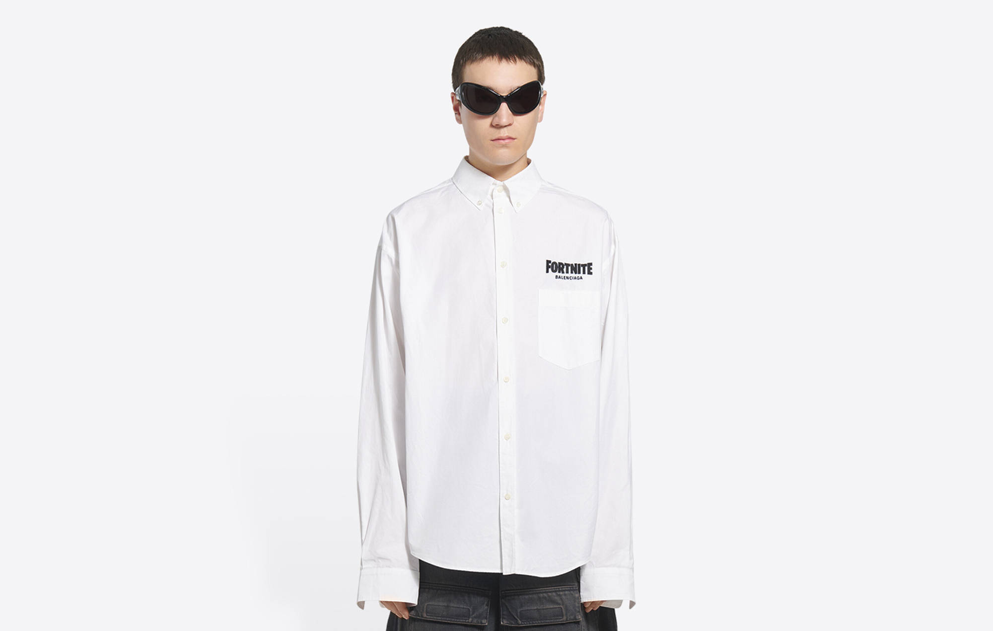 Balenciaga 桌布 壁紙 — 一個人穿著白色鈕扣襯衫，胸前有Fortnite標誌，戴著深色太陽眼鏡，站在純白色背景前。