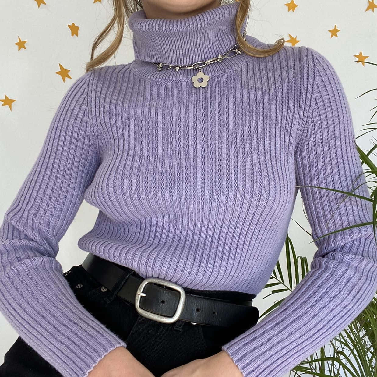 Purple Turtle-neck Sweater 桌布 壁紙 — 一個人穿著薰衣草色羅紋高領毛衣，戴著銀色花鏈項鍊，背景是星星圖案的牆壁和綠色植物。