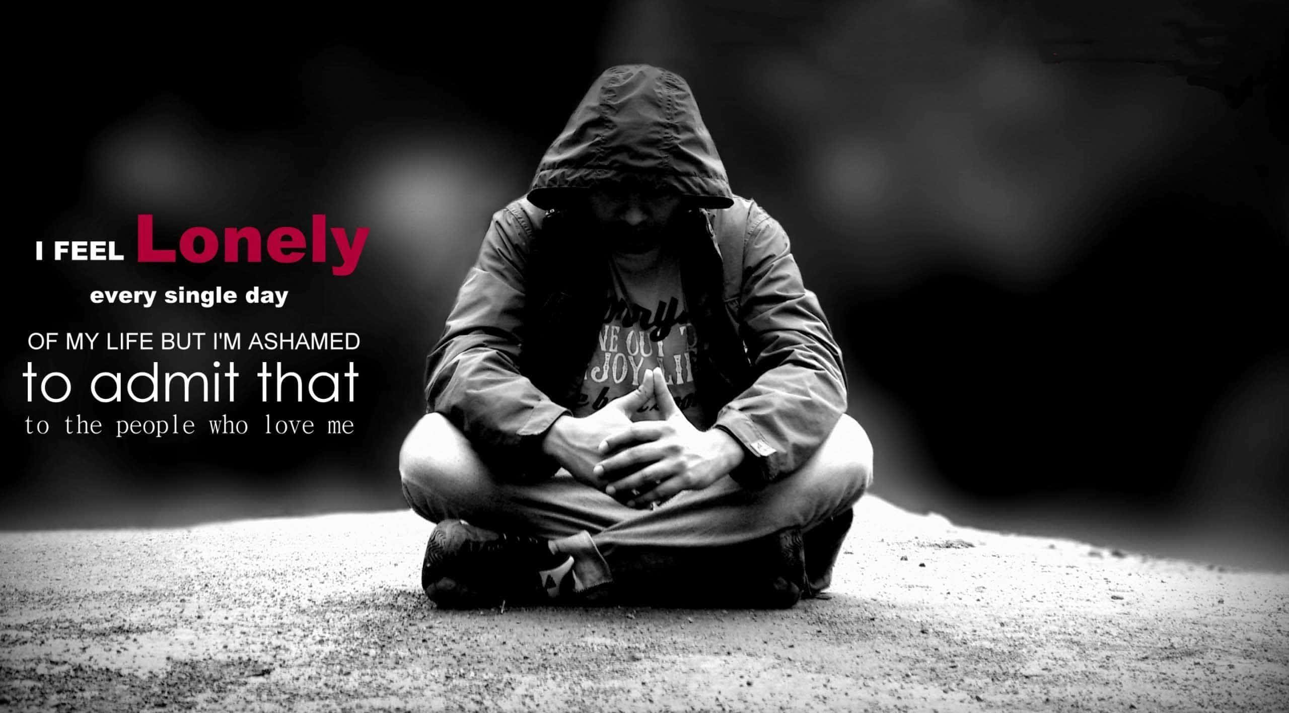 Lonely 桌布 壁紙 — 一個人穿著連帽外套，雙手交握蜷縮在人行道上，在模糊的黑暗背景下傳達出深深的孤獨感。