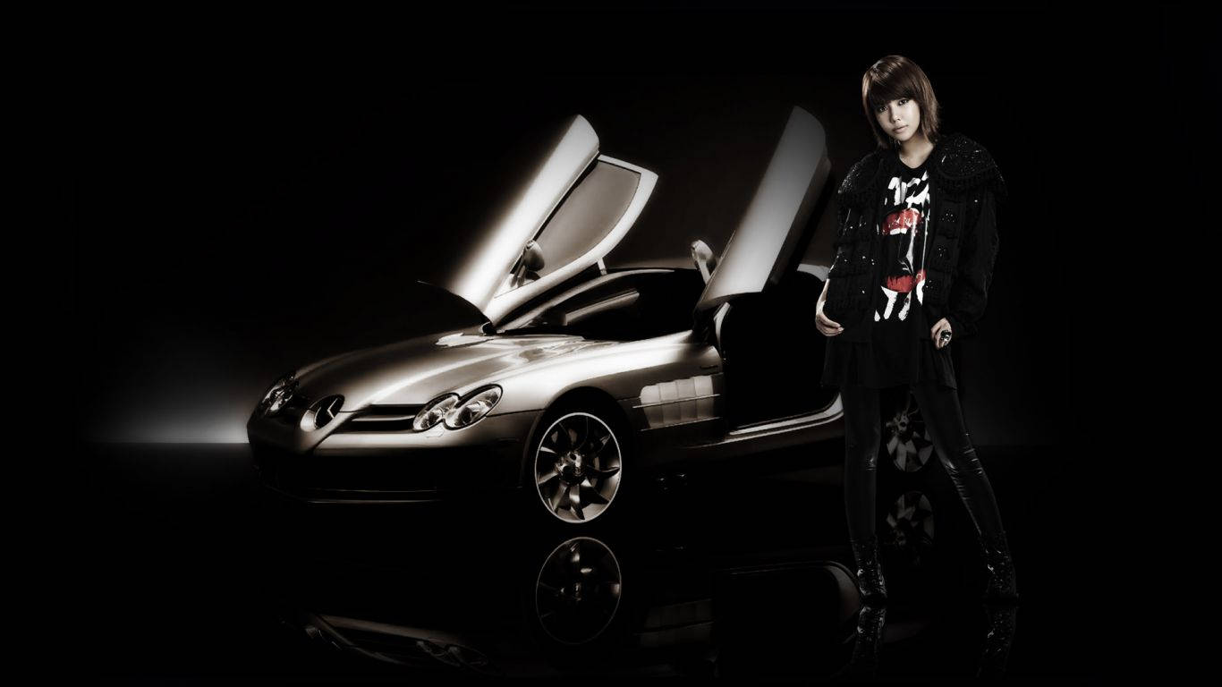 girls 桌布 壁紙 — 一個人站在一輛銀色鷗翼門跑車旁邊，背景為黑色，帶有戲劇性的聚光燈。