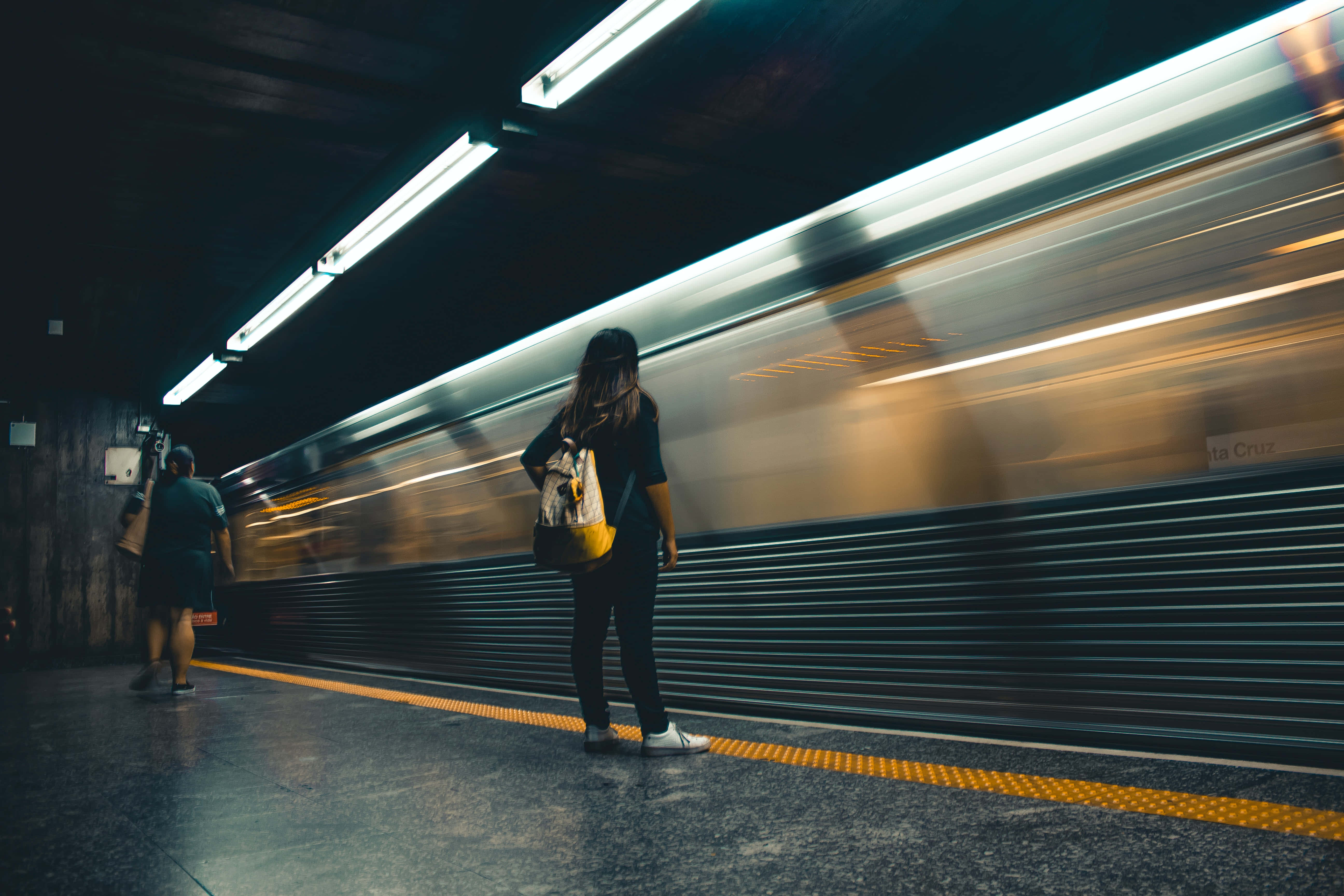 Waiting 桌布 壁紙 — 一個人站在地鐵月台上，一列高速列車帶著光線模糊駛過。