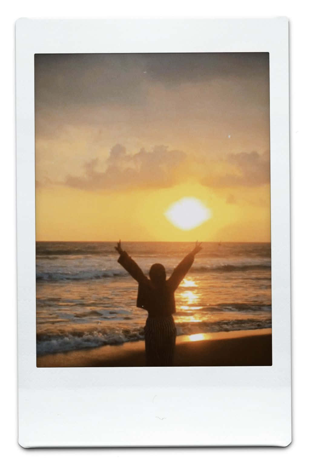 Aesthetic Polaroid 桌布 壁紙 — 一個人站在沙灘上，日落時分雙臂高舉向海洋上發光的太陽。