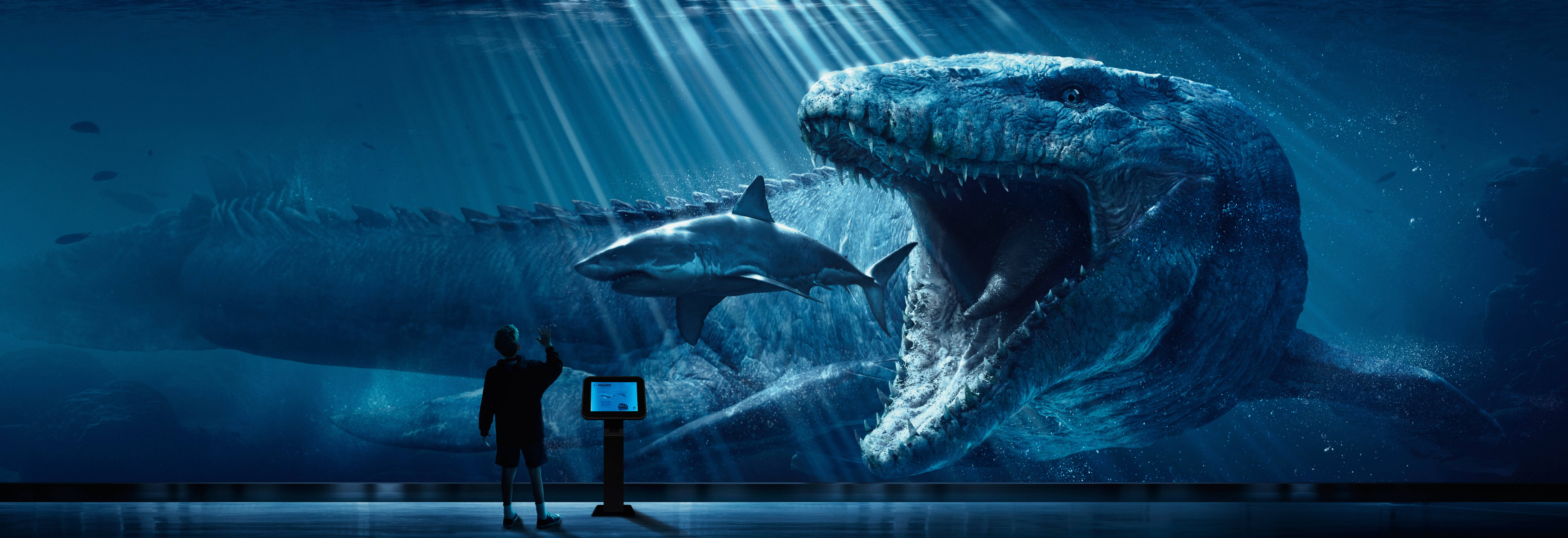 World 桌布 壁紙 — 一個人站在深藍色水族館展覽中，敬畏地看著巨大的史前海怪和鯊魚。