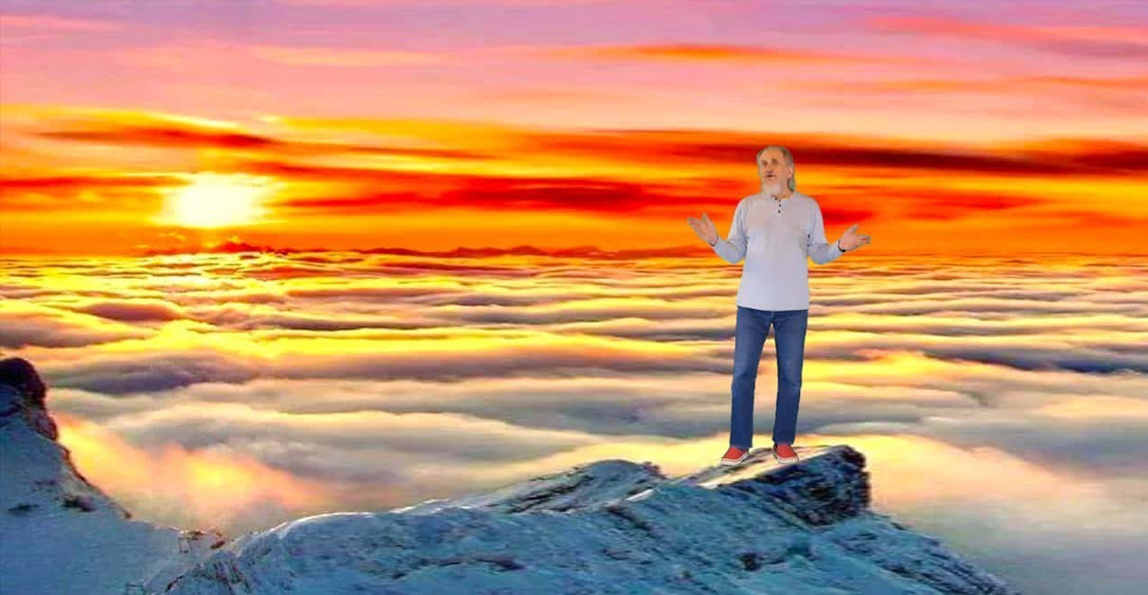 Beautiful Heaven 桌布 壁紙 — 一個人站在白雪覆蓋的懸崖上，俯瞰著沐浴在熾熱日落色調中的雲海。