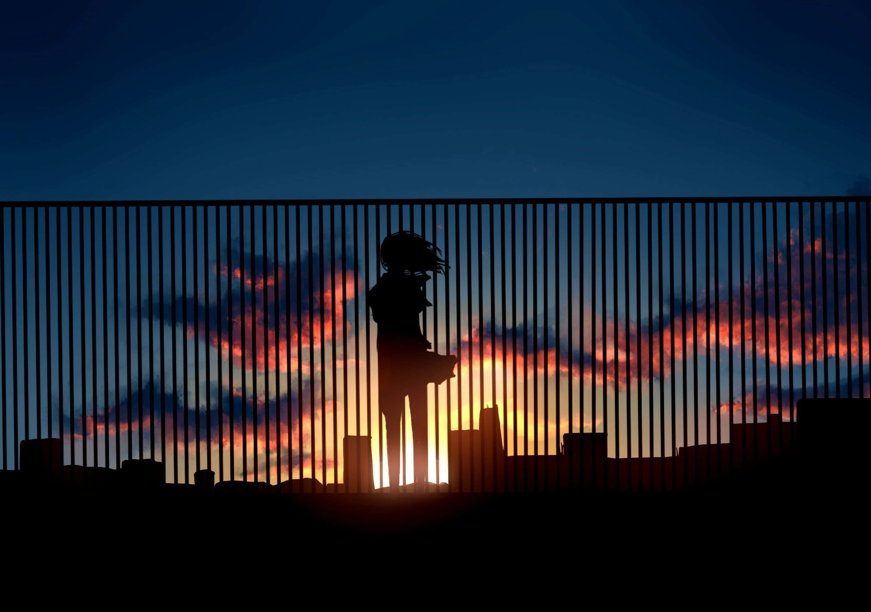 Anime Sunset 桌布 壁紙 — 一個人站在籬笆後面的剪影，背景是充滿活力的日落天空，帶有橙色和藍色的雲彩。