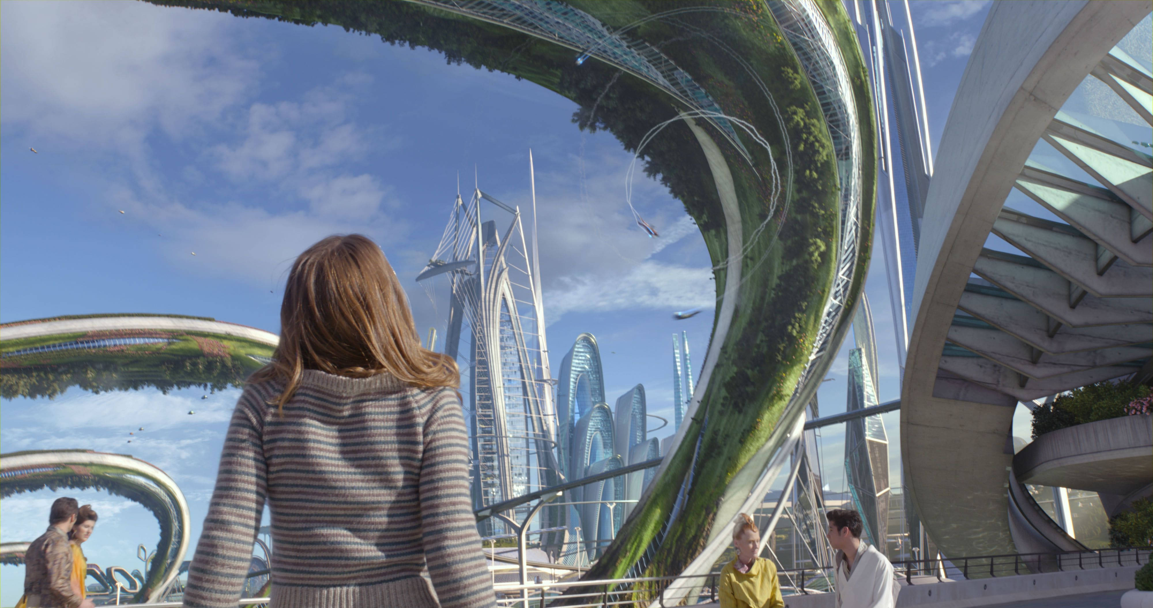 Tomorrowland Movie 桌布 壁紙 — 一個人走過一座未來主義城市，高聳的玻璃摩天大樓和巨大的綠色藤蔓覆蓋的拱門在明亮的藍天下。
