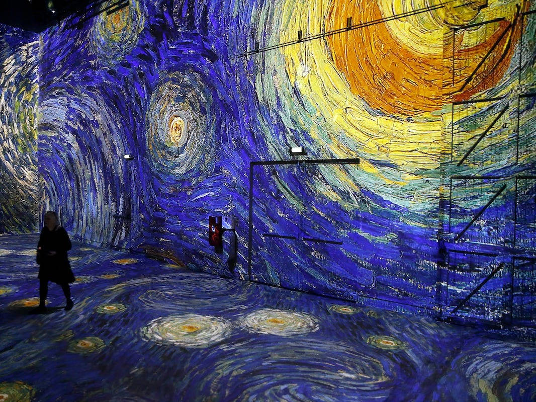 訪客在博物館中走過沉浸式《星夜》投影 — 巴黎 GIF 壁紙