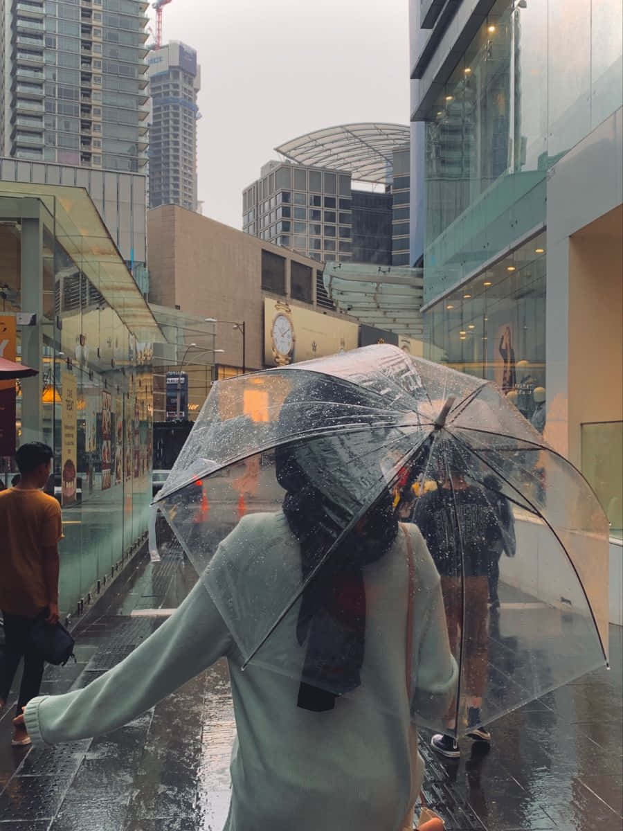 垃圾美學 桌布 壁紙 — 一個人走開，手持透明雨傘，雨滴在現代城市小巷中流淌。