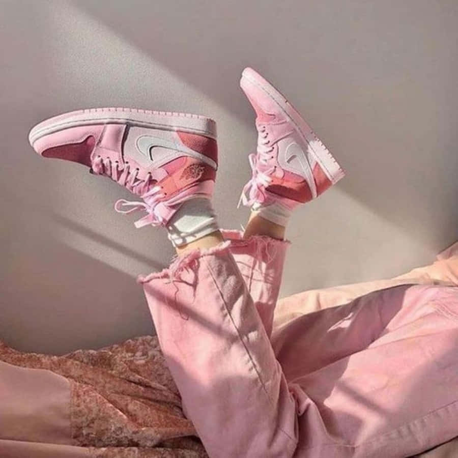 Pink Shoes 桌布 壁紙 — 一個人躺在床上，穿著粉紅色Nike運動鞋和相配的粉紅色褲子，陽光在後面的牆上投下柔和的陰影。