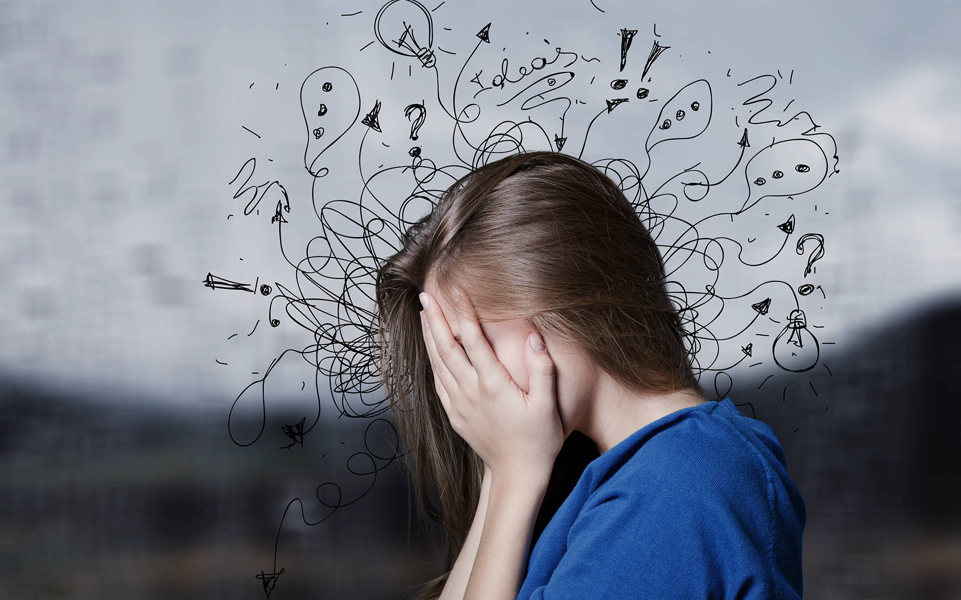 Anxiety 桌布 壁紙 — 一個人遮住臉，混亂的手繪塗鴉（燈泡、問號和驚嘆號）在他們頭頂旋轉。