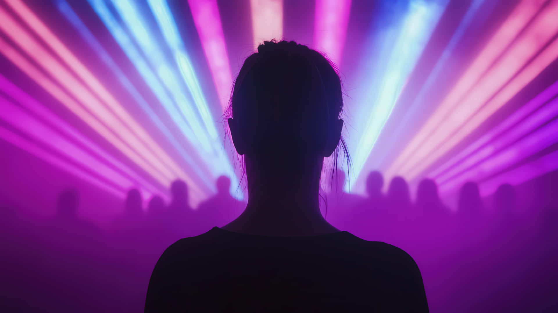 Silhouette of a Woman at a Concert with Vibrant Laser Lights 壁紙 — 一個人面向充滿活力的紫色和藍色雷射燈光的剪影，背後有人群陰影。