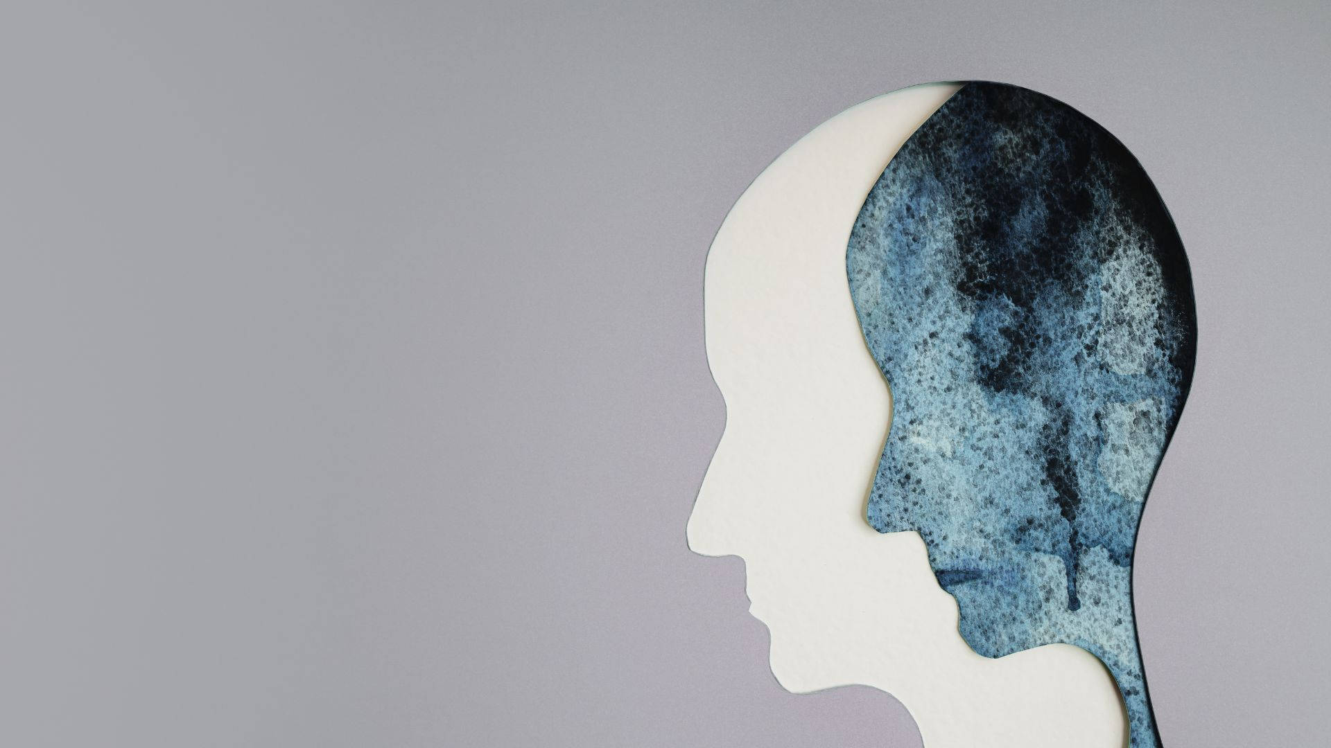 mind 桌布 壁紙 — 一個人頭剪影分成兩半，一半是純白色，另一半是帶紋理的藍灰色水彩。