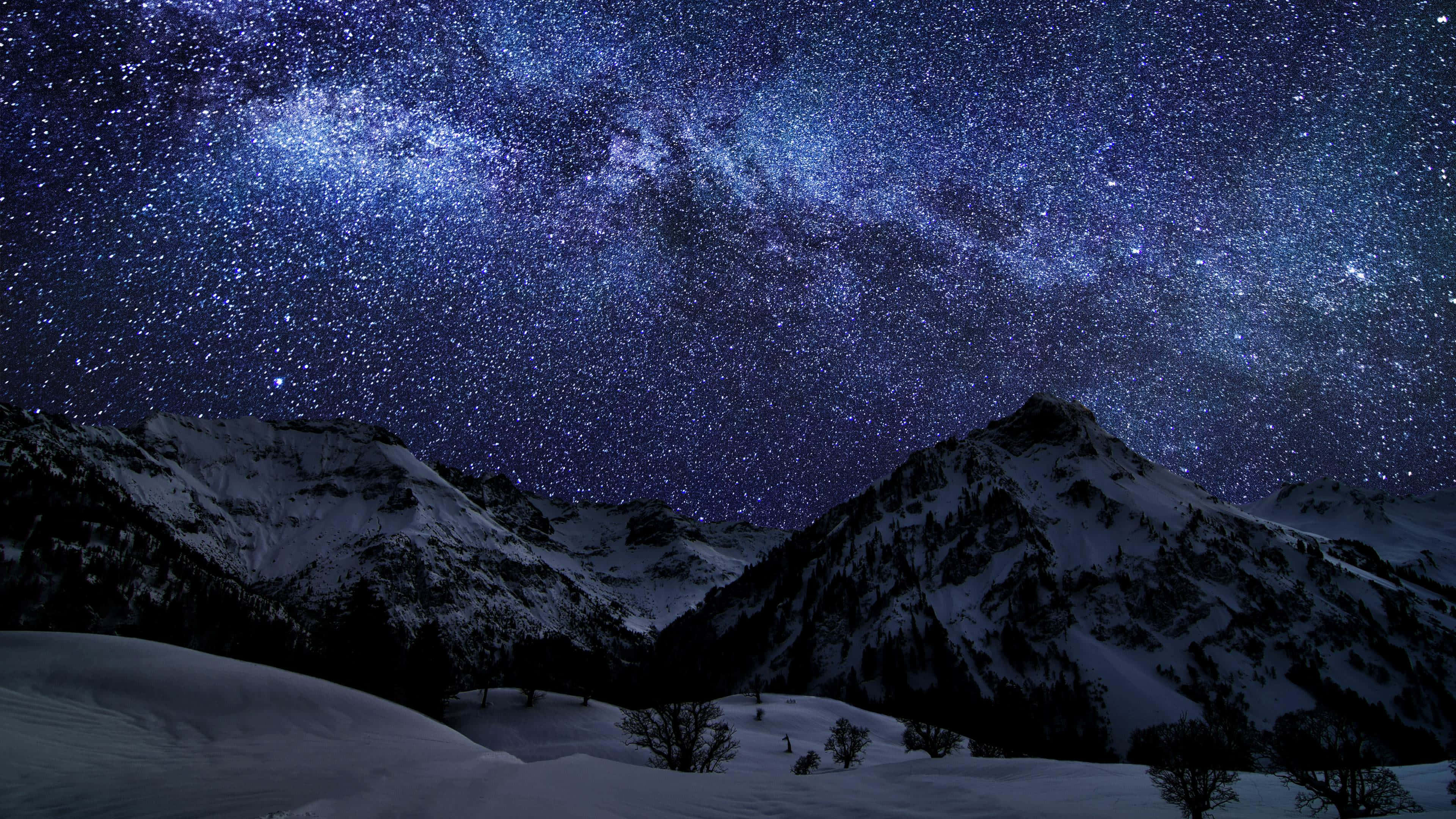 Beautiful Space 桌布 壁紙 — 一個令人嘆為觀止的冬夜場景，白雪覆蓋的山脈在充滿活力的星空下，銀河清晰可見。