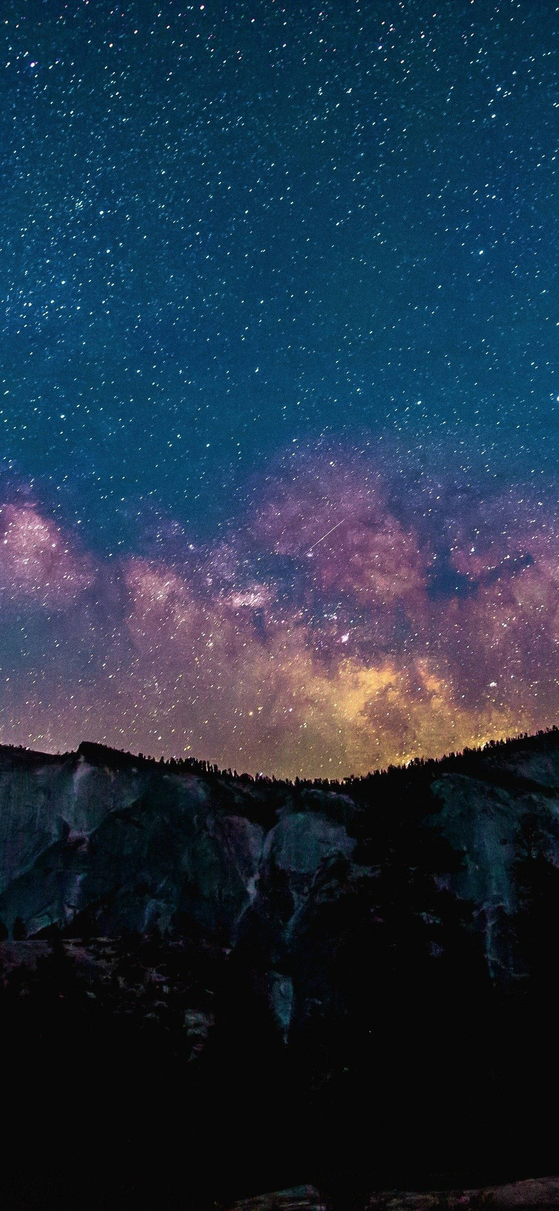 Star Space 桌布 壁紙 — 一個令人嘆為觀止的夜空，佈滿星星和銀河，拱形橫跨在黑暗剪影的山脈之上。