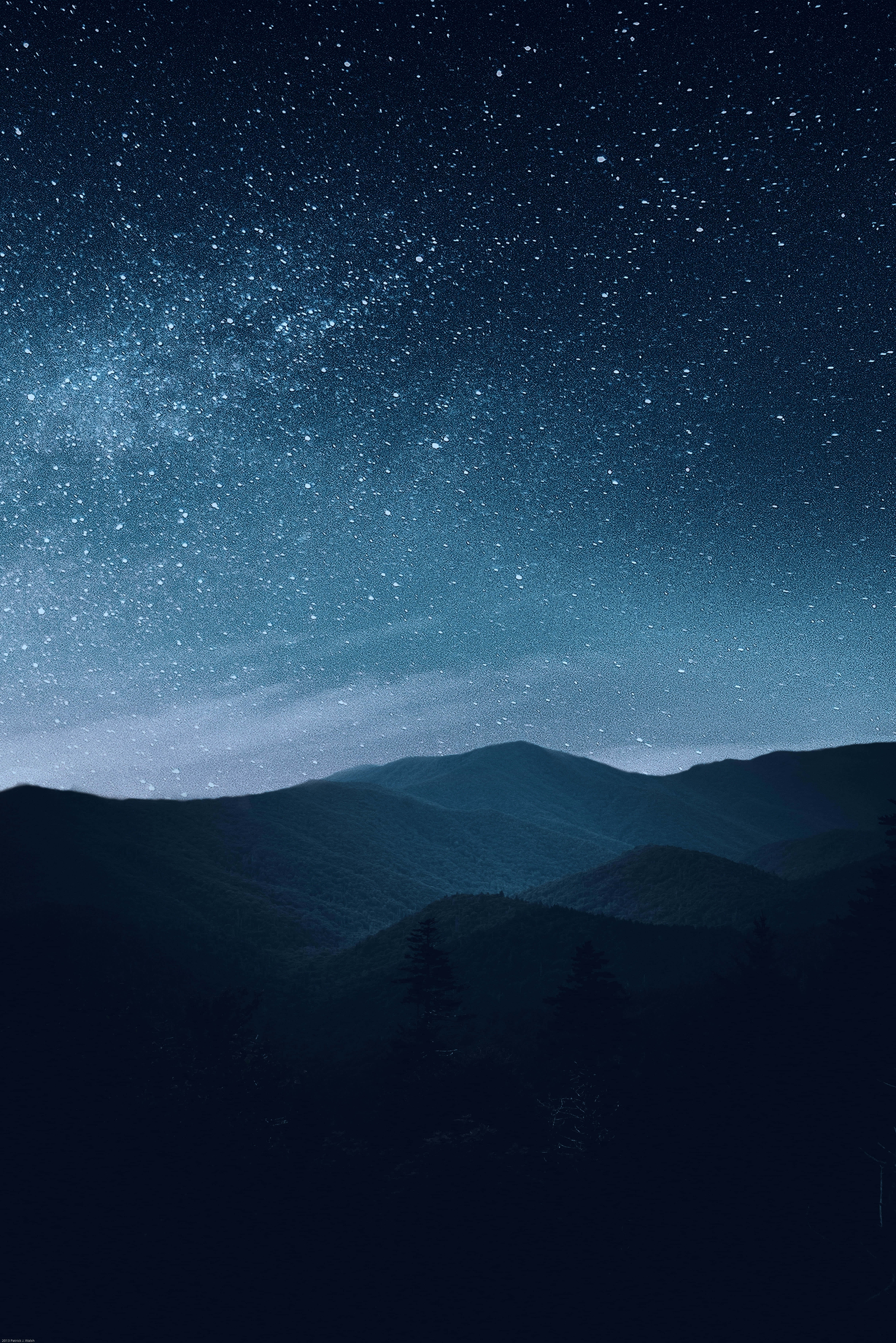 桌布 壁紙 — 一個令人嘆為觀止的夜空，充滿了無數星星，銀河在剪影般的山脊上拱起。