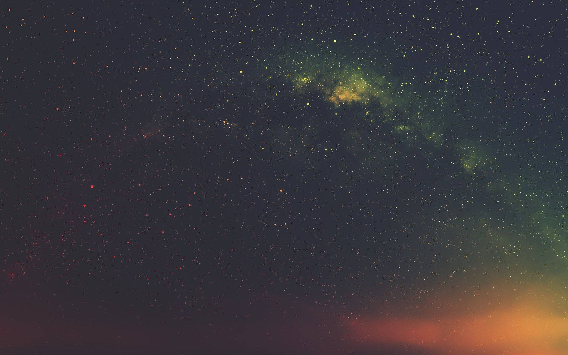 背景 桌布 壁紙 — 一個令人嘆為觀止的夜空，充滿無數星星和發光的綠色星雲，背景是深藍色和溫暖橙色的漸變。