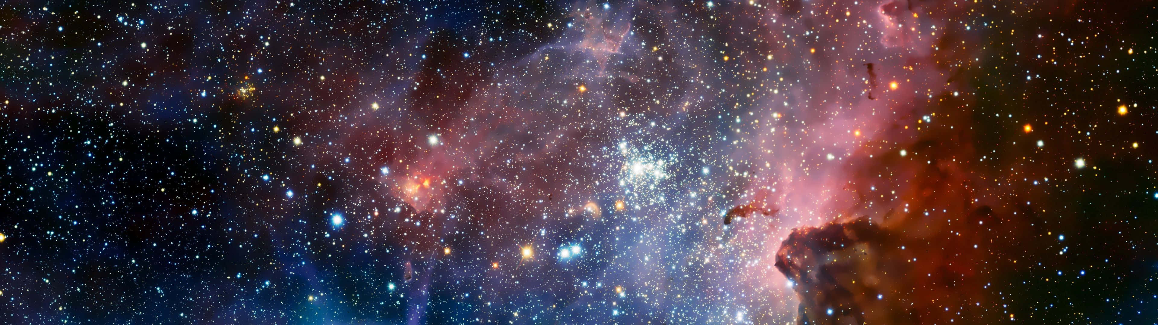 Stars 桌布 壁紙 — 一個令人嘆為觀止的宇宙全景，展示出在星空中閃耀著紅色、紫色和藍色的鮮豔星雲。
