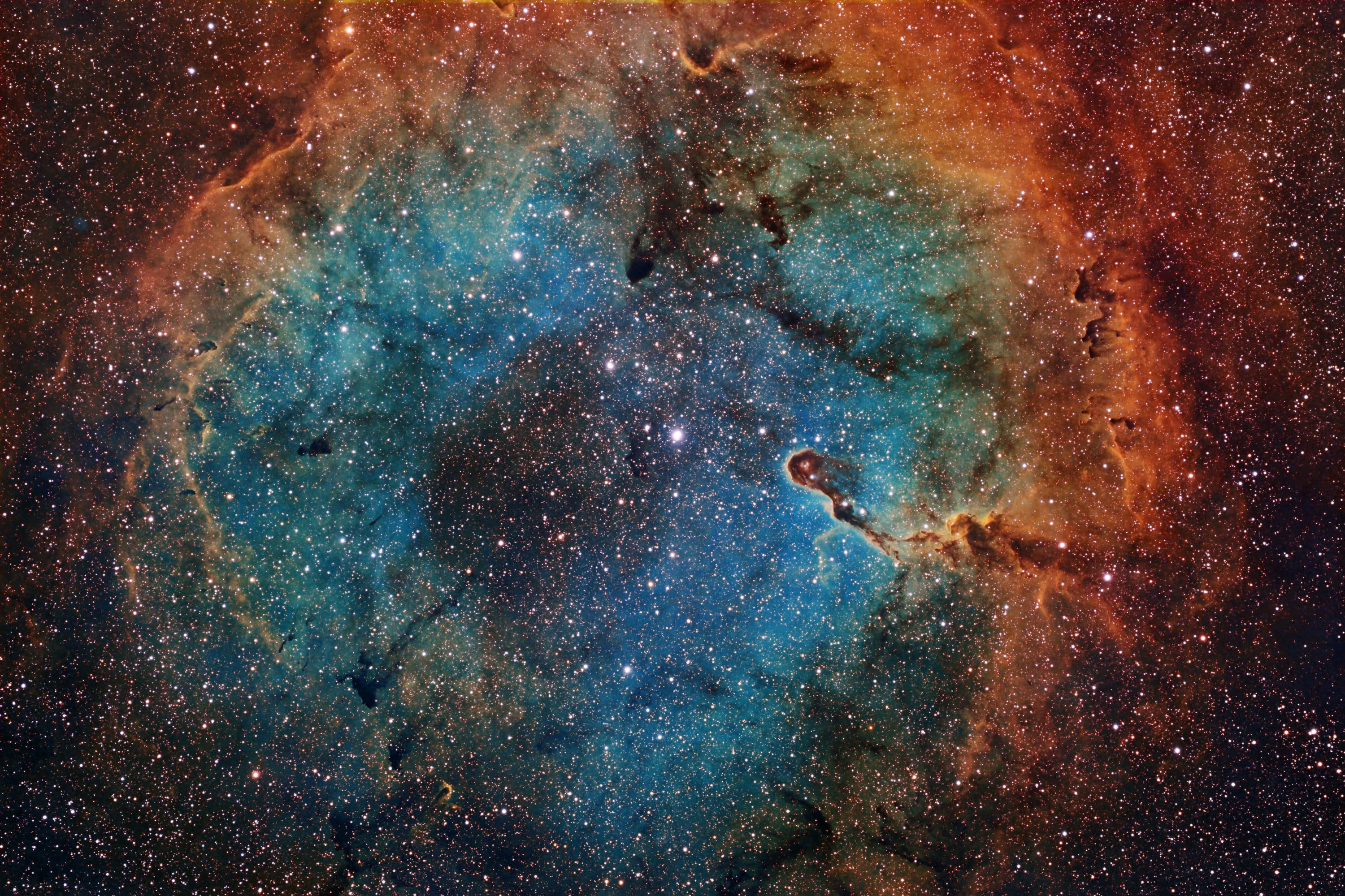 Astrophysics 桌布 壁紙 — 一個令人嘆為觀止的宇宙星雲，在佈滿星辰的虛空中旋轉著鮮豔的藍色和火熱的橙色氣體。