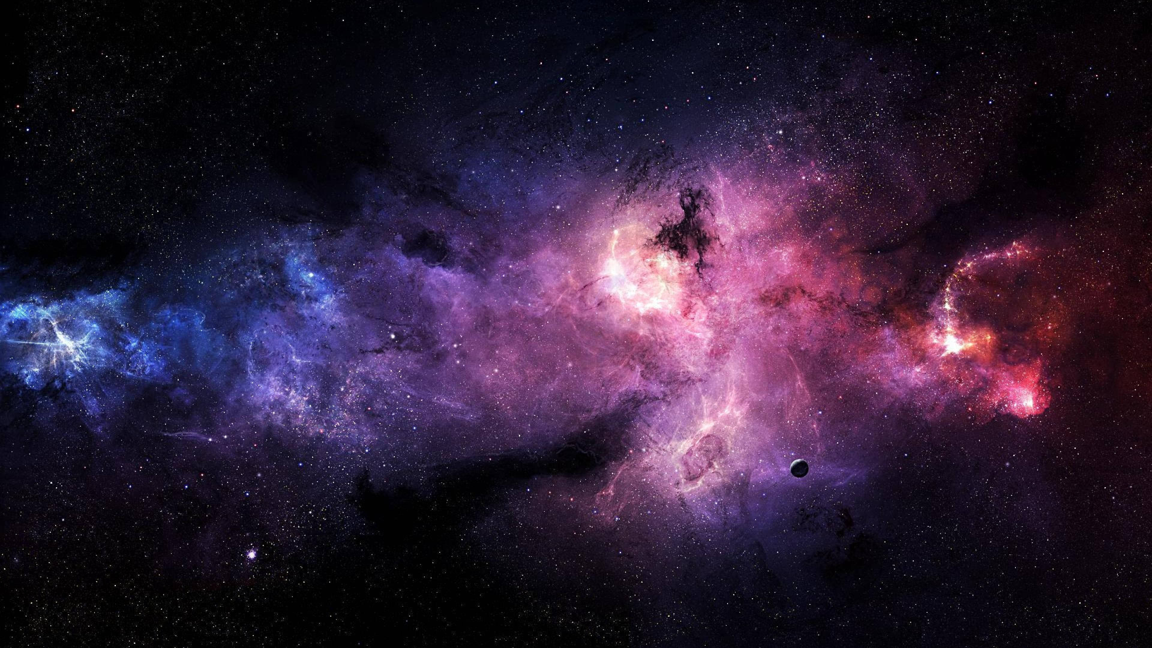 4K Computer 桌布 壁紙 — 一個令人嘆為觀止的宇宙星雲，在星空背景下旋轉著充滿活力的粉紅色、紫色和藍色氣體。