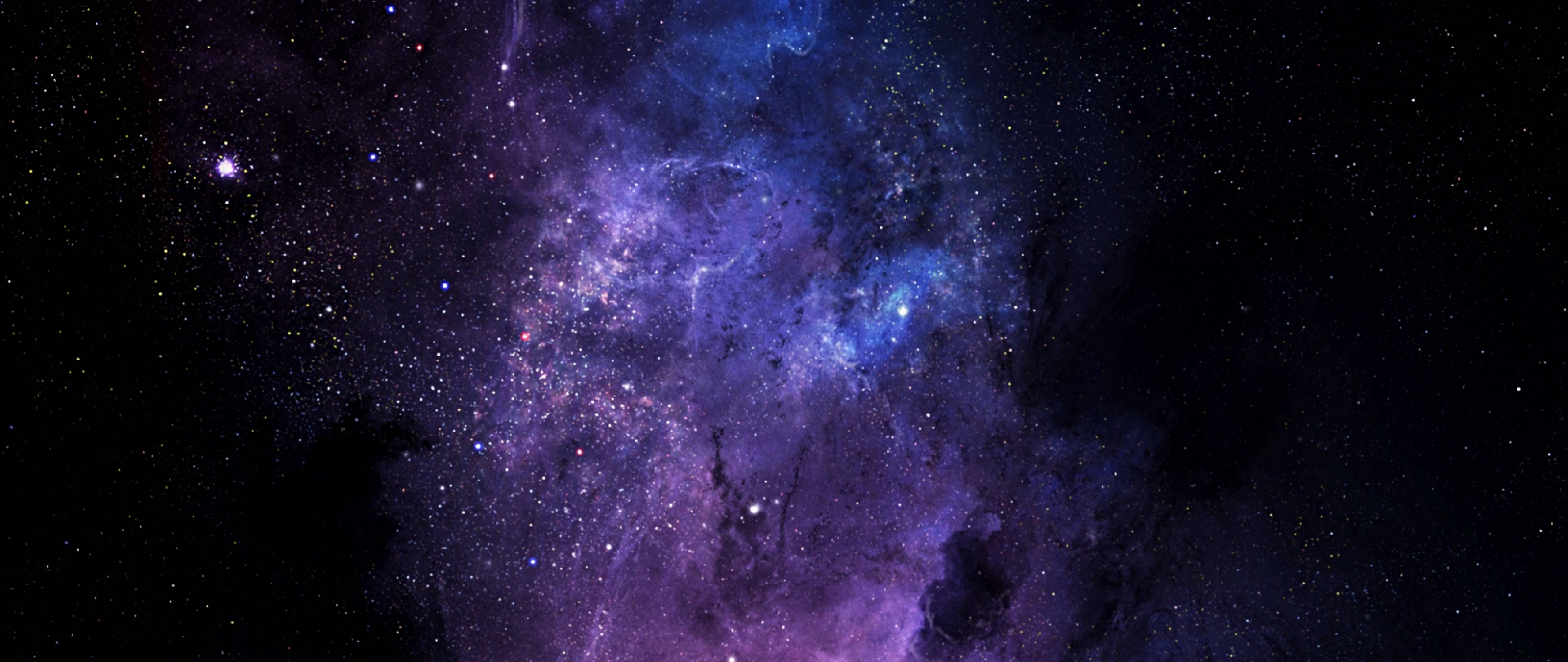 宇宙 桌布 壁紙 — 一個令人嘆為觀止的宇宙星雲在佈滿星辰的黑色虛空中旋轉，呈現出鮮豔的紫色和藍色。