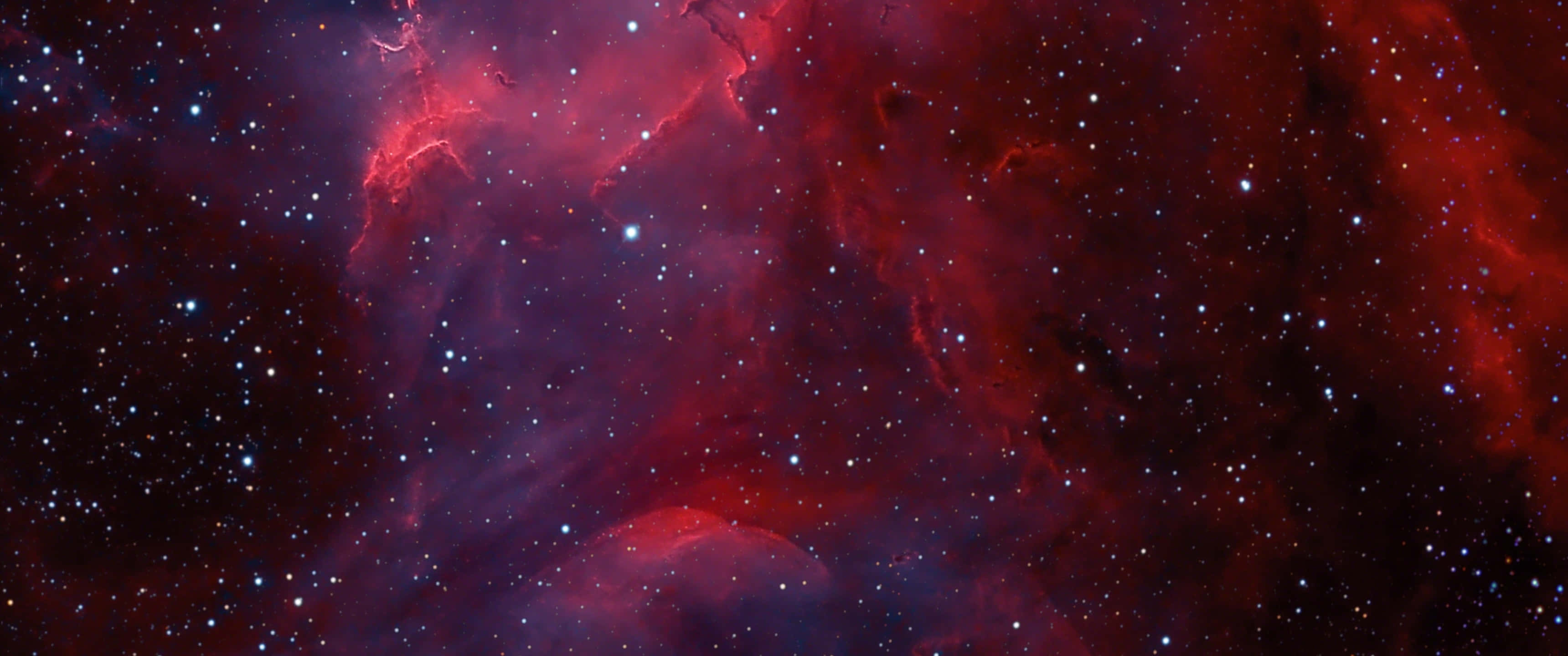 桌布 壁紙 — 一個令人嘆為觀止的宇宙星雲景觀，在星空中閃耀著深紅和紫色。
