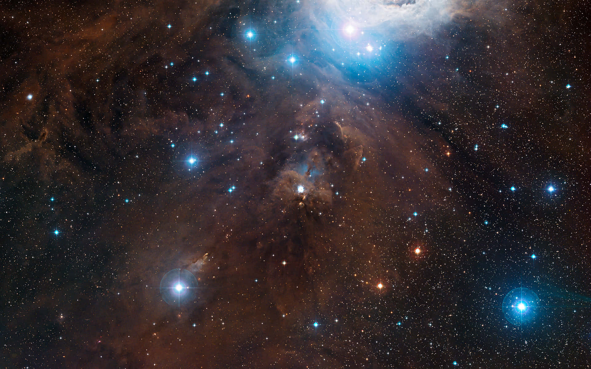 Starry Sky 桌布 壁紙 — 一個令人嘆為觀止的宇宙星雲景觀，在佈滿星星的黑色虛空中散發著藍色和橙色的光芒。
