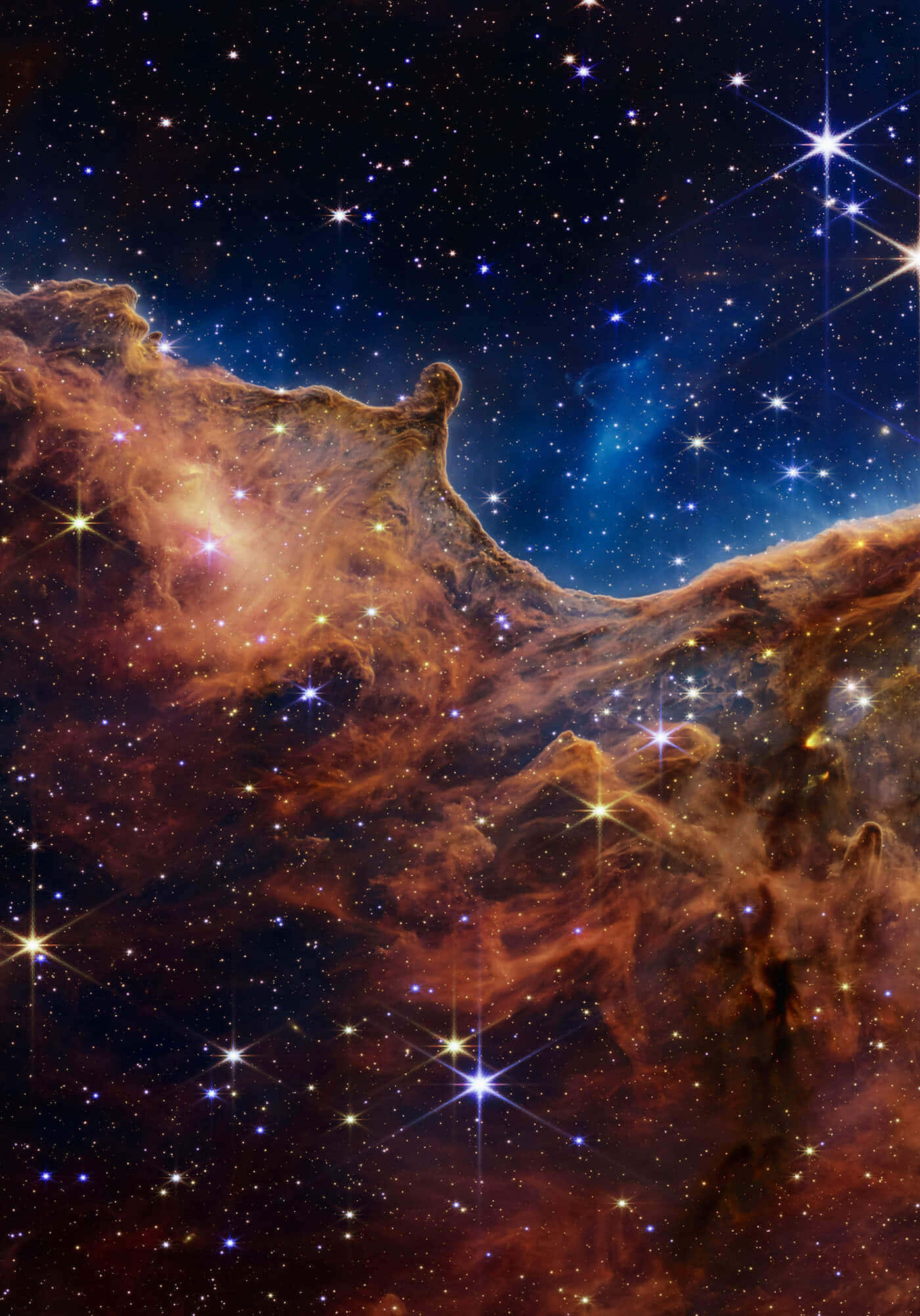 Telescope 桌布 壁紙 — 一個令人嘆為觀止的宇宙星雲景觀，帶有發光的橙色和藍色雲朵，由閃爍的星星在深邃的黑色天空中照亮。