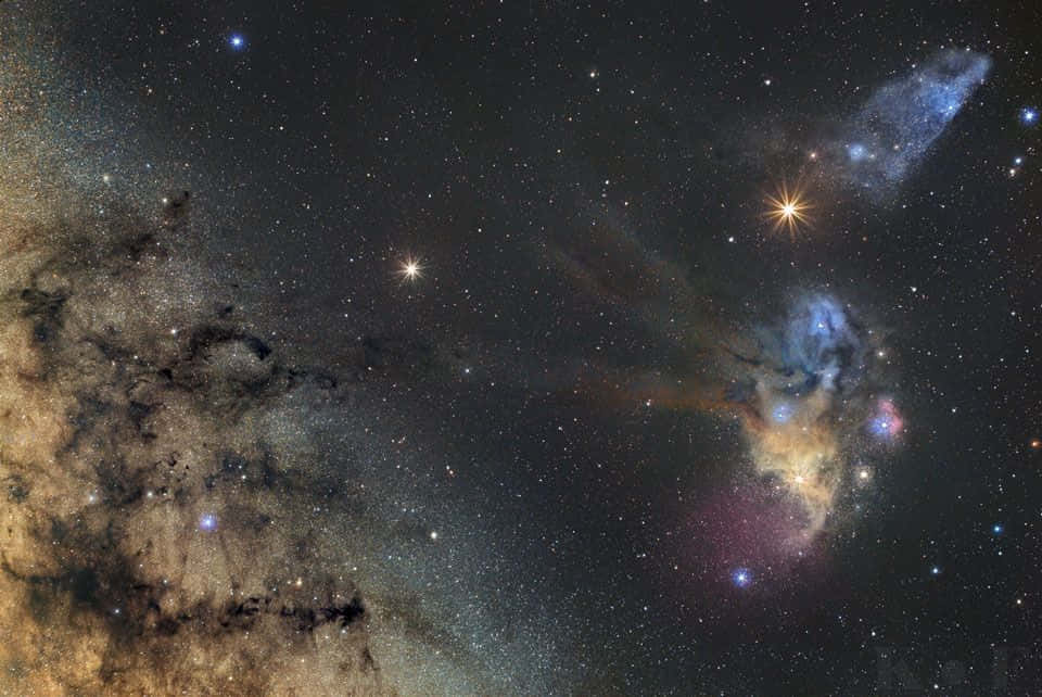 Interstellar Cloud 桌布 壁紙 — 一個令人嘆為觀止的宇宙星雲景象，在星空中散發出藍色、粉紅色和橙色的光芒。
